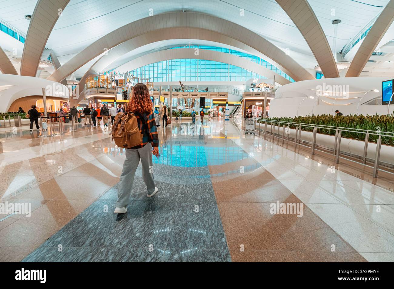 23 janvier 2025, Abu Dhabi, Émirats arabes Unis : voyageuse marchant dans le hall spacieux d'un terminal d'aéroport moderne Banque D'Images