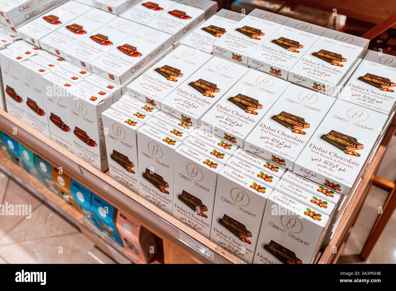 23 janvier 2025, Abu Dhabi, Émirats arabes Unis : barres de chocolat Dubaï avec garniture de kunafa et de pistache empilées sur une étagère de magasin, prêtes à être achetées Banque D'Images