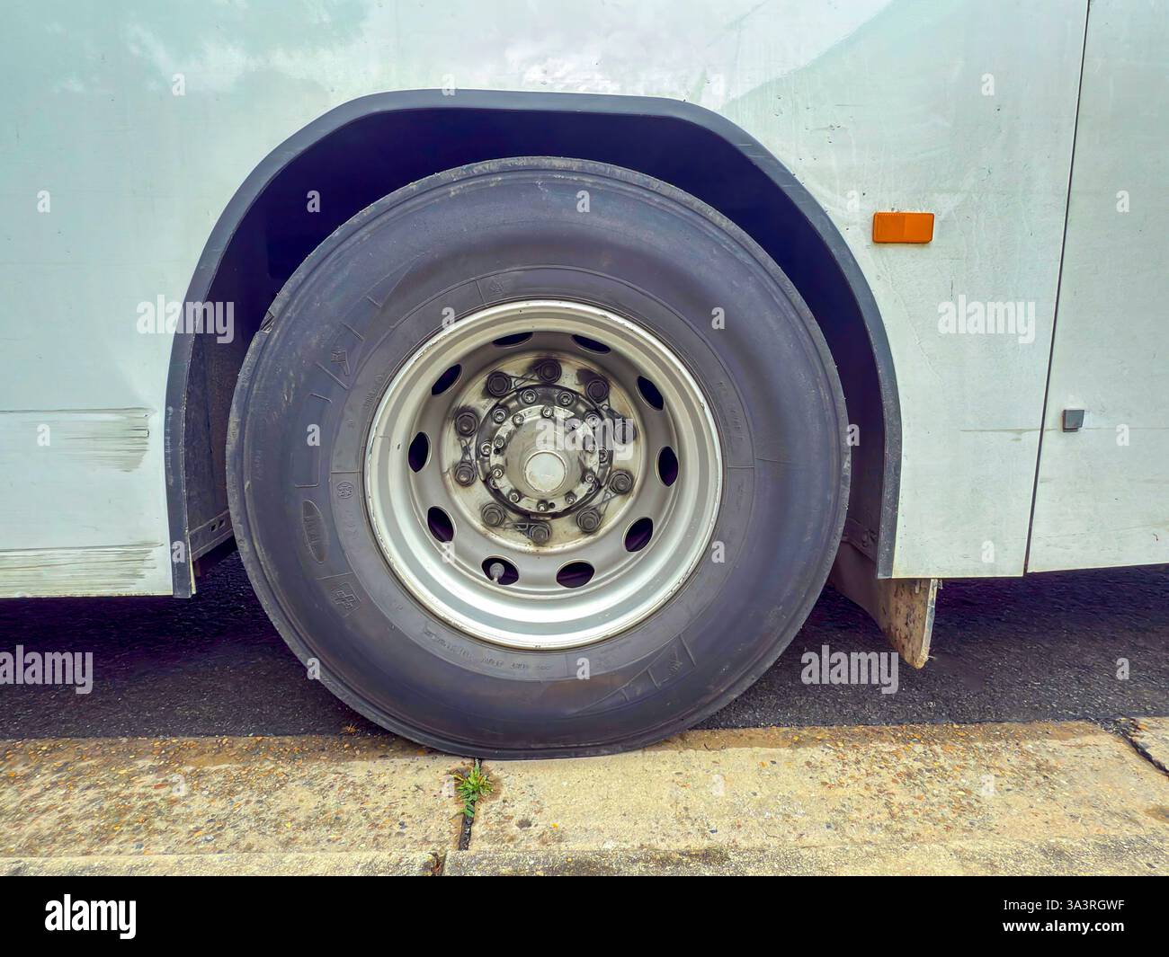 Photographie d'un pneu et d'une jante d'autobus qui ont été bien utilisés et qui indiquent la charge de travail élevée des véhicules de transport public. Banque D'Images