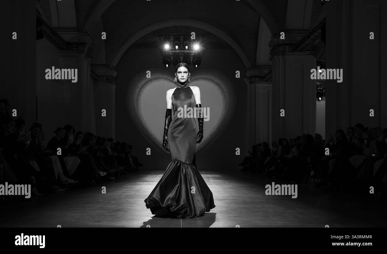 Kiev, Ukraine - 14 février 2025. Un modèle présente une robe à couper le souffle avec un flair dramatique, incarnant la créativité et le style ukrainiens pendant la GU Banque D'Images