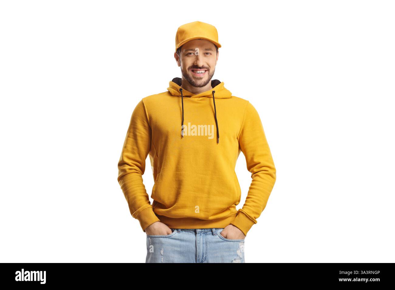 Jeune homme dans un sweat à capuche jaune et un Jean posant avec les mains dans des poches isolées sur fond blanc Banque D'Images Jeune homme dans un sweat à capuche jaune et un Jean posant avec les mains dans des poches isolées sur fond blanc Banque D'Images