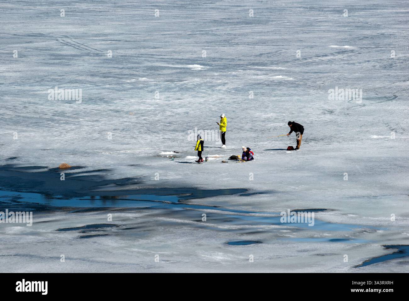 La famille profite de la température glaciale pour profiter d'une sortie familiale de pêche sur glace dans le Colorado. ÉTATS-UNIS Banque D'Images