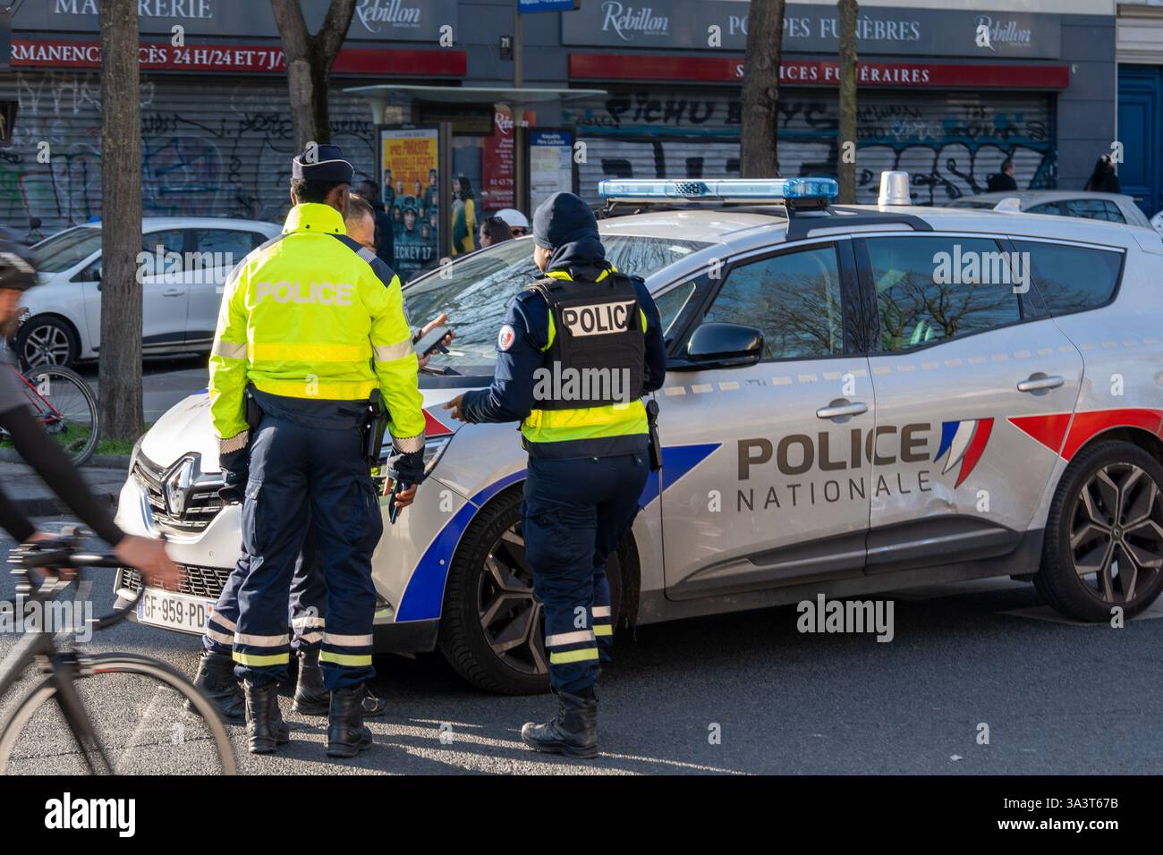 Les policiers s'engagent dans des tâches importantes tout en assurant la sécurité publique lors d'une journée ensoleillée dans le centre-ville Banque D'Images