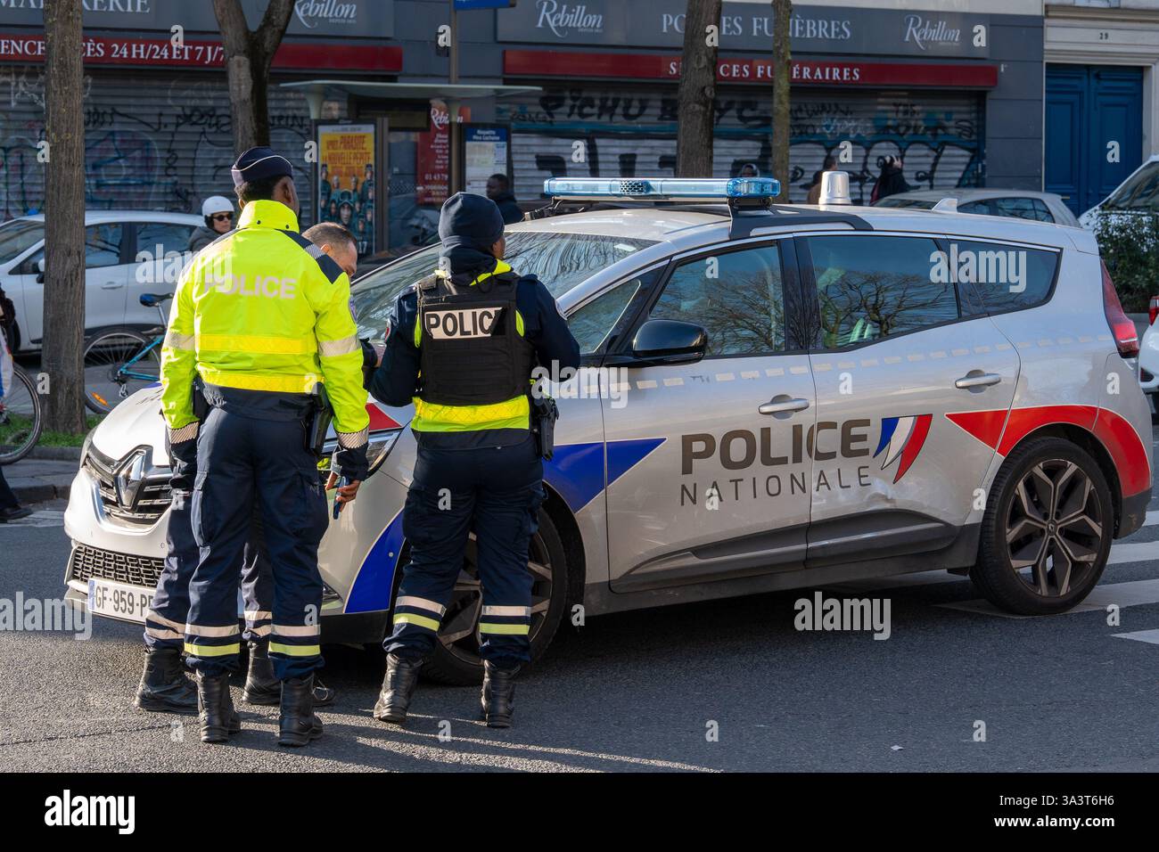 Les policiers engagent une conversation près d'un véhicule de patrouille sur la rue de la ville pendant les heures de jour Banque D'Images