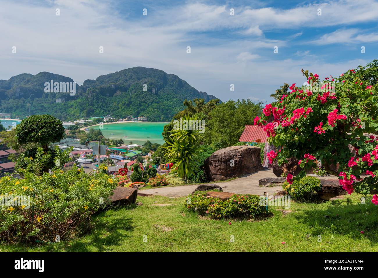 Îles Phi Phi, Thaïlande - un point de vue tropical pittoresque avec des fleurs vibrantes, une végétation luxuriante, des eaux turquoises et des montagnes calcaires majestueuses Banque D'Images