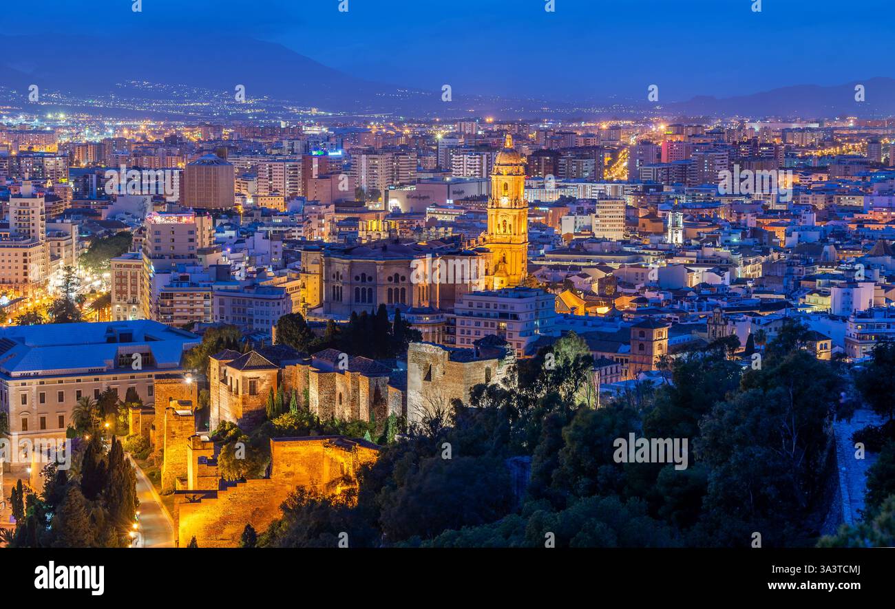 Málaga, Espagne - 7 mai 2016 : un paysage nocturne époustouflant avec la cathédrale illuminée et l'ancienne alcazaba au milieu d'une ville animée Banque D'Images