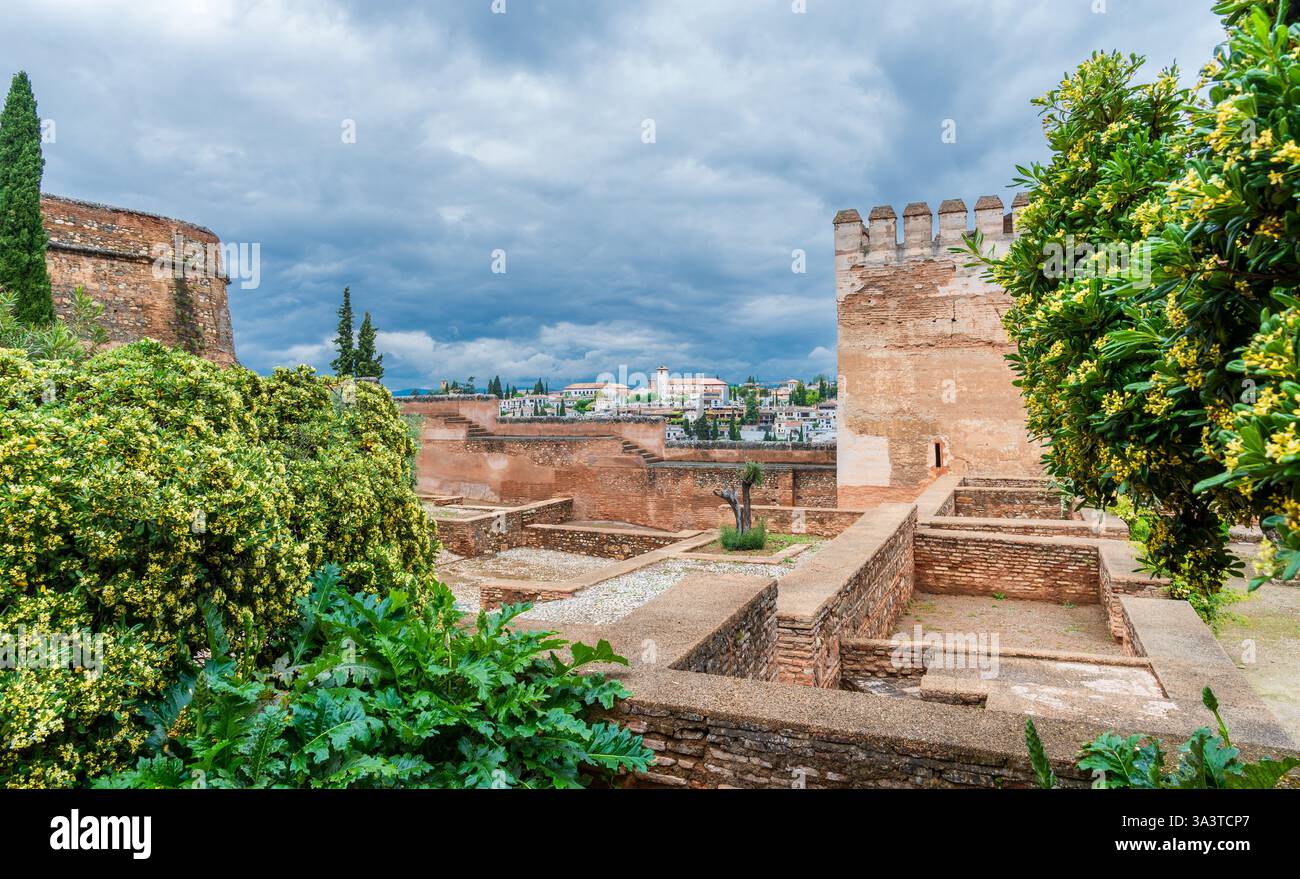 Grenade, Espagne - les anciens murs de la forteresse de l'Alhambra surplombant le quartier de Albaicín sous un ciel nuageux spectaculaire Banque D'Images