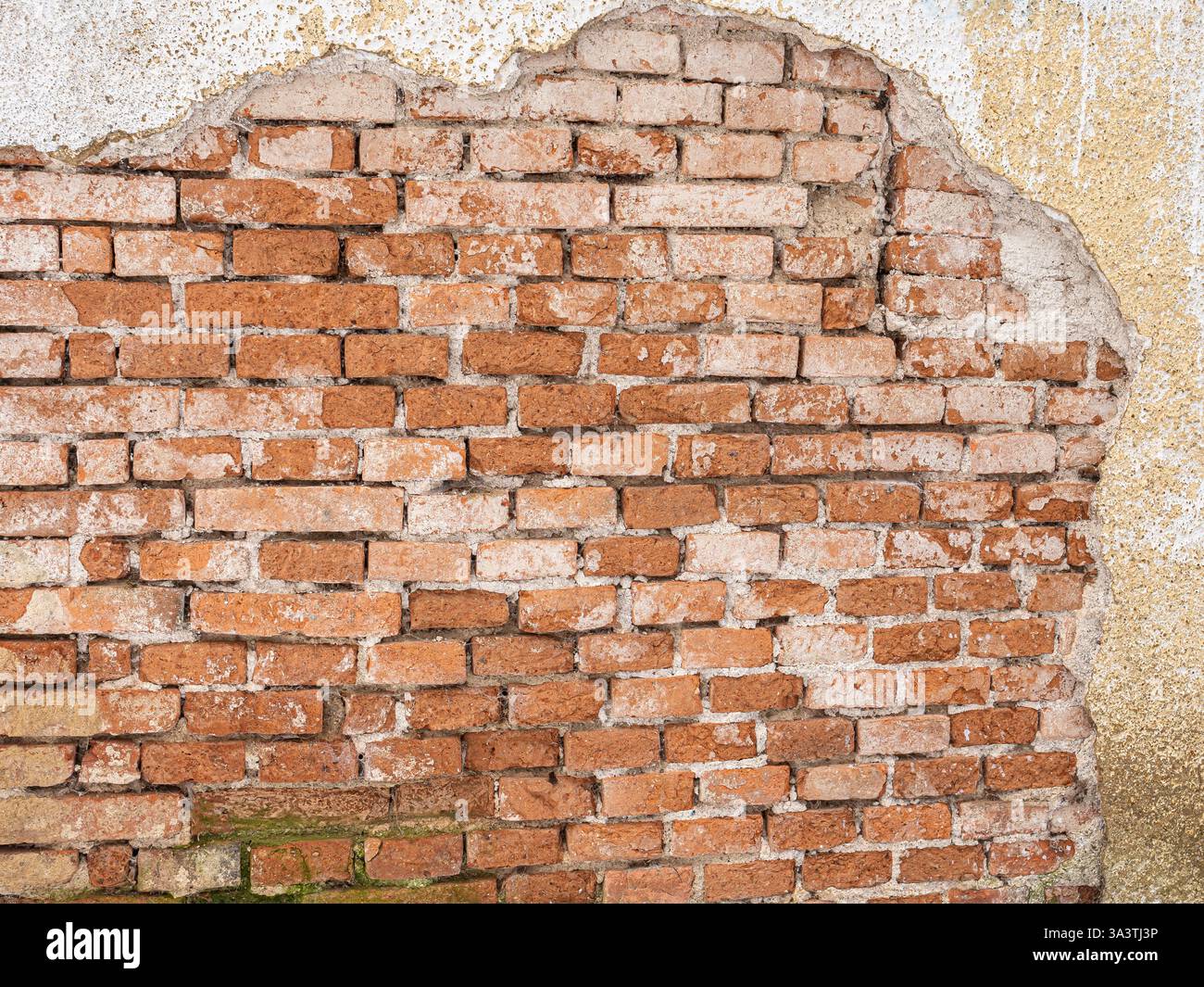 vieux mur de briques altérées avec plâtre en ruine exposant partiellement des briques rouges, texture rugueuse, construction ancienne, architecture historique, rustique et w. Banque D'Images