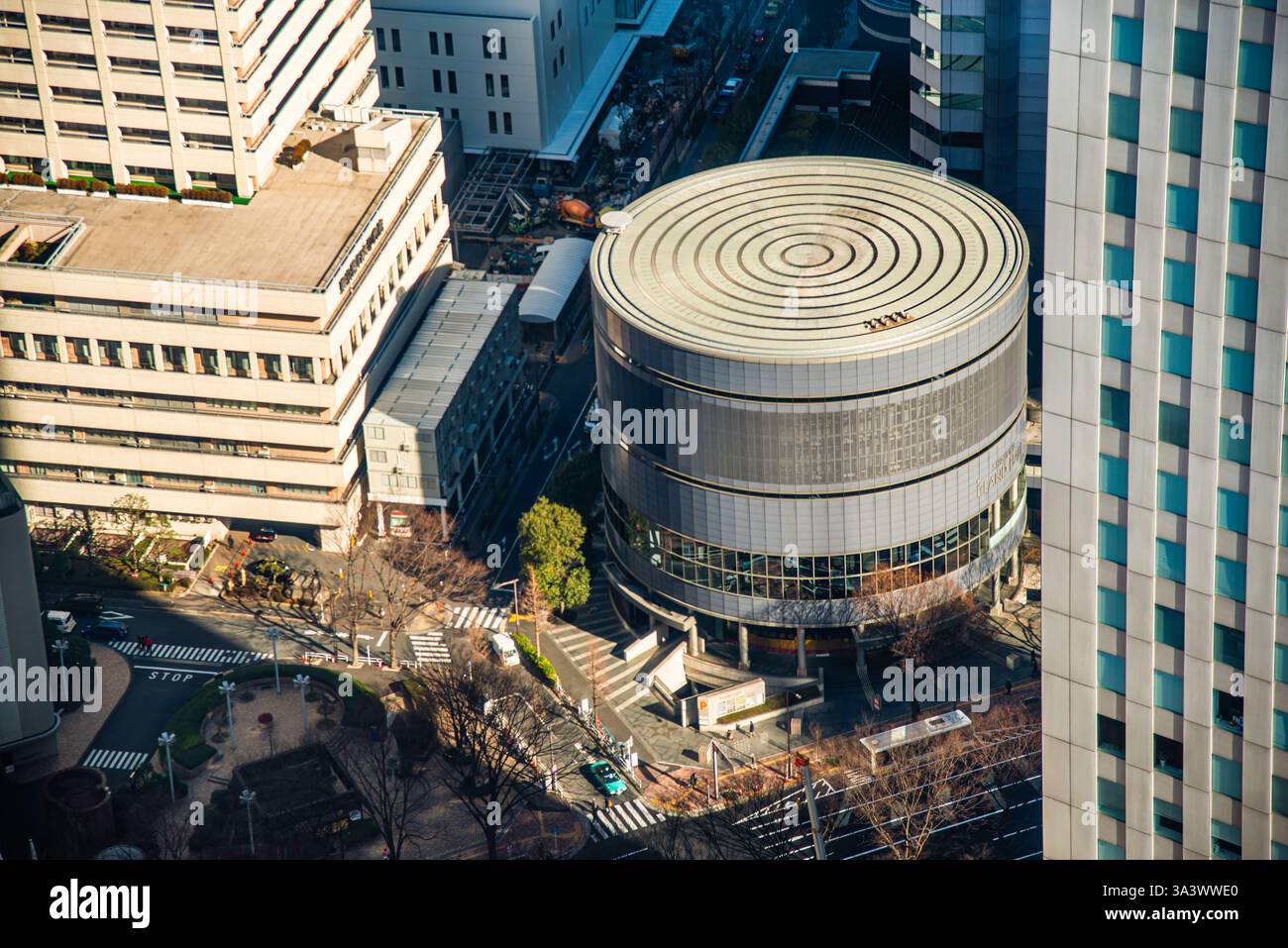 Vue aérienne du Shinjuku Sumitomo Building Plaza Hall à Tokyo, Japon. La structure circulaire moderne est entourée d'immeubles de bureaux, de passages pour piétons, Banque D'Images