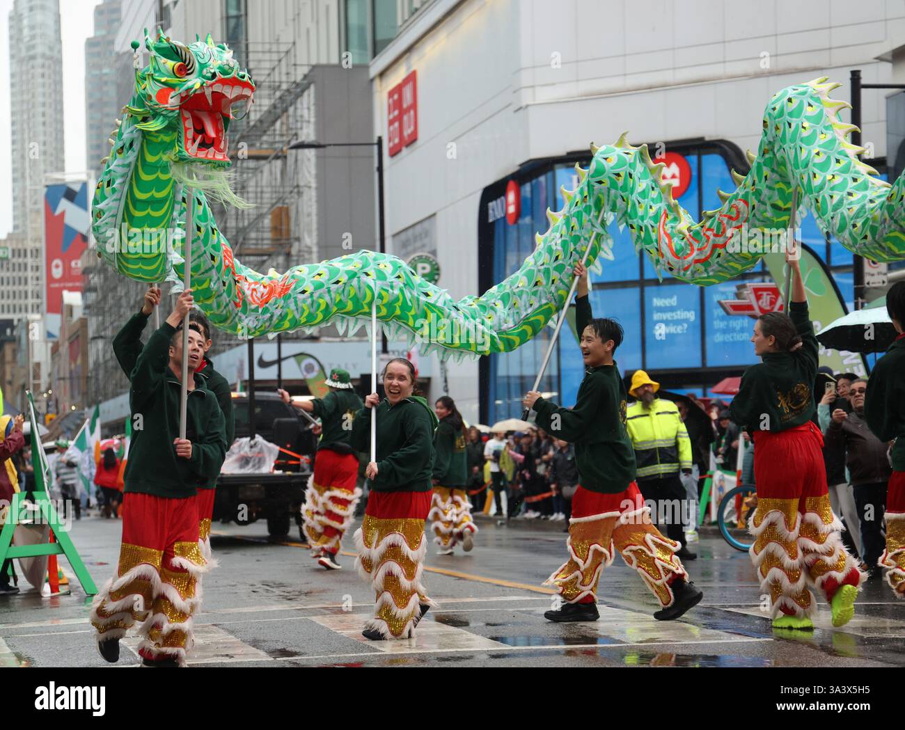 Une équipe de danse du dragon exécute la danse traditionnelle chinoise du dragon. Toronto, Canada.16 mars 2025. Un grand défilé célébrant la fête de Saint Patrick a eu lieu à Toronto, Canada, le 16 mars 2025. Crédit : Yu Ruidong/China News Service/Alamy Live News Banque D'Images