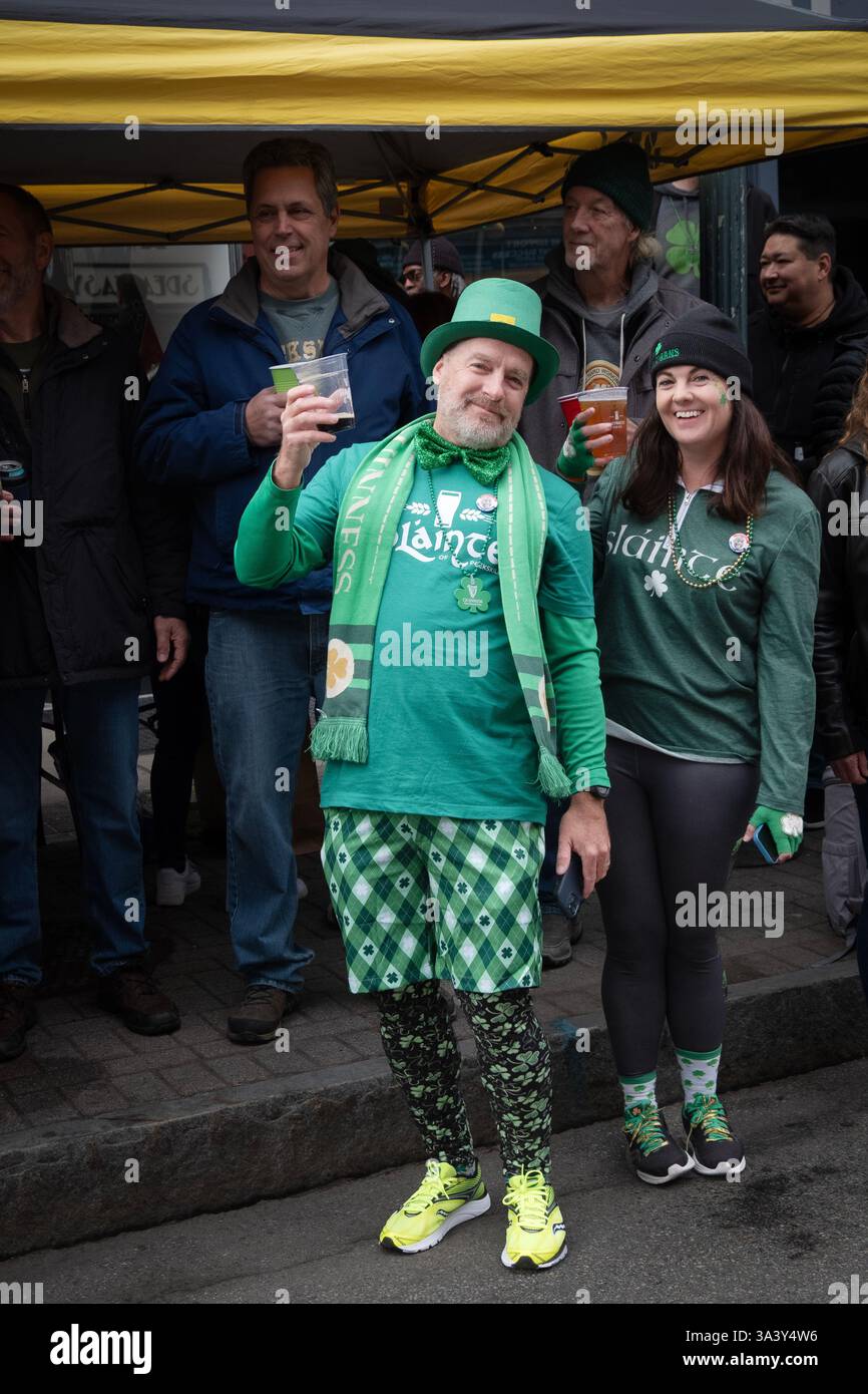Mariés et vêtus de vert, ils lèvent leurs verres de bière tout en regardant la parade de la St Patrick en 2025 devant Slainte of Peekskill à New Yor Banque D'Images