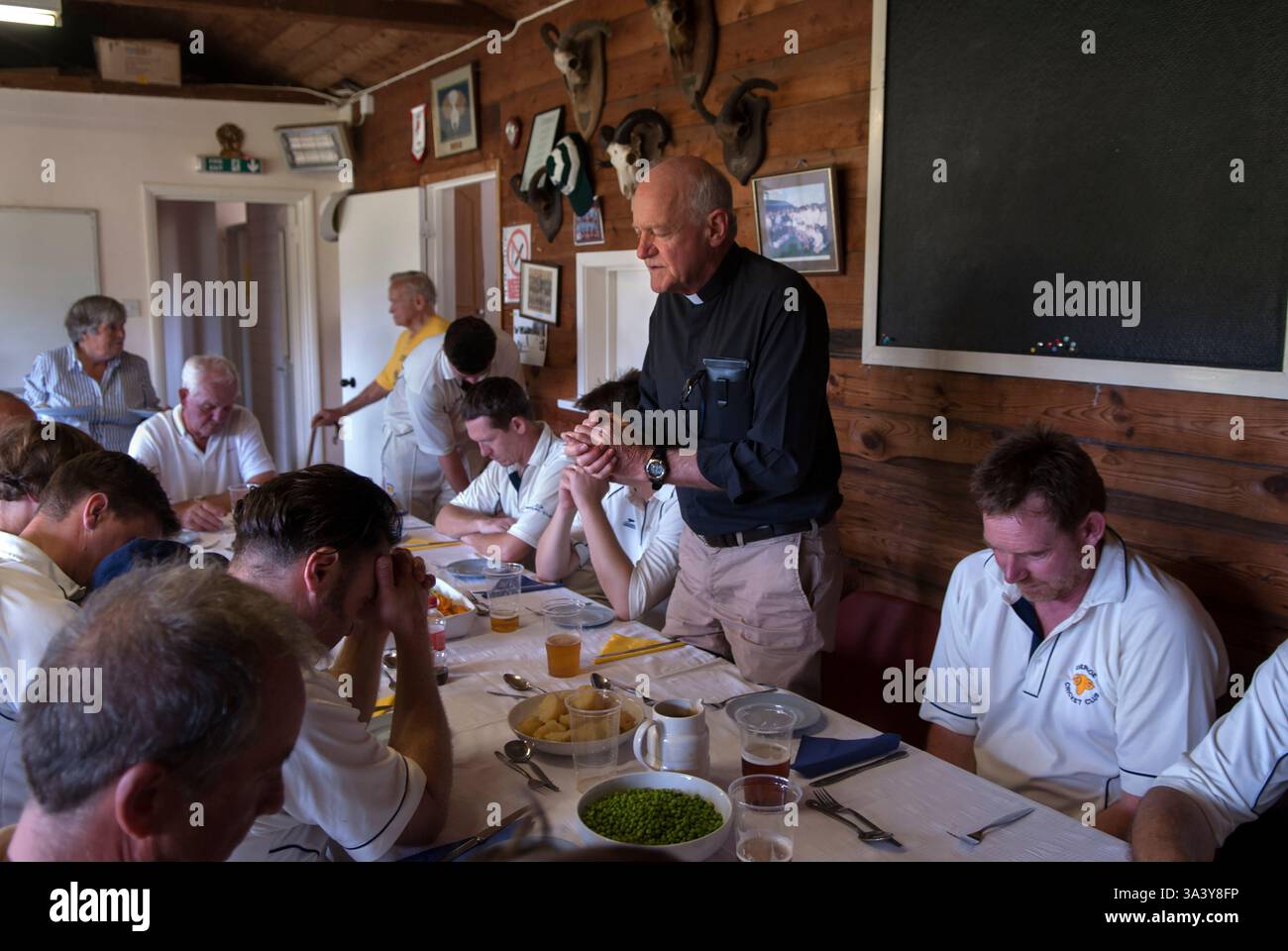 Dire Grace les têtes sont inclinées et il y a silence. Une courte prière est dite par le vicaire de l'église d'Ebernoe avant le traditionnel déjeuner rôti d'agneau de la Foire d'Ebernoe Horn qui est servi aux deux équipes de cricket dans le pavillon de cricket du village. Saint-Jacques (25 juillet). Ebernoe, West Sussex, Angleterre 25 juillet 2015 2010s Royaume-Uni HOMER SYKES Banque D'Images