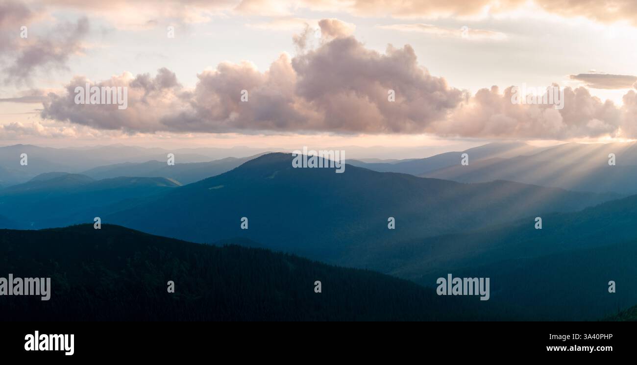 Magnifique paysage montagneux printanier avec des crêtes bleues ondulantes qui brillent dans la chaleur du soleil levant. Montagnes des Carpates. Photographie de paysage Banque D'Images
