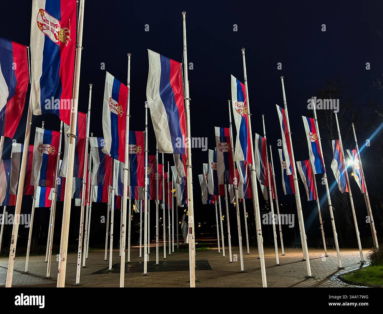 Drapeaux serbes abaissés en Berne en l'honneur du jour de deuil de nuit, symbolisant le respect et le souvenir. - Image de stock capturée avec un smartphone