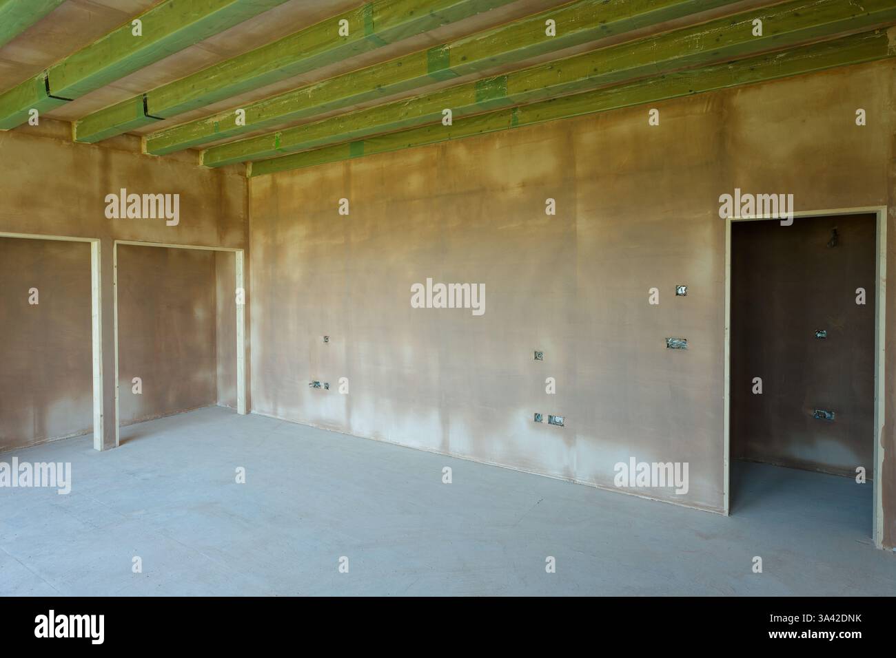Une salle nouvellement plâtrée avec commutation électrique, premiers inserts de câblage. Travaux de construction finis avec une surface plane lisse de plâtre mince. Banque D'Images