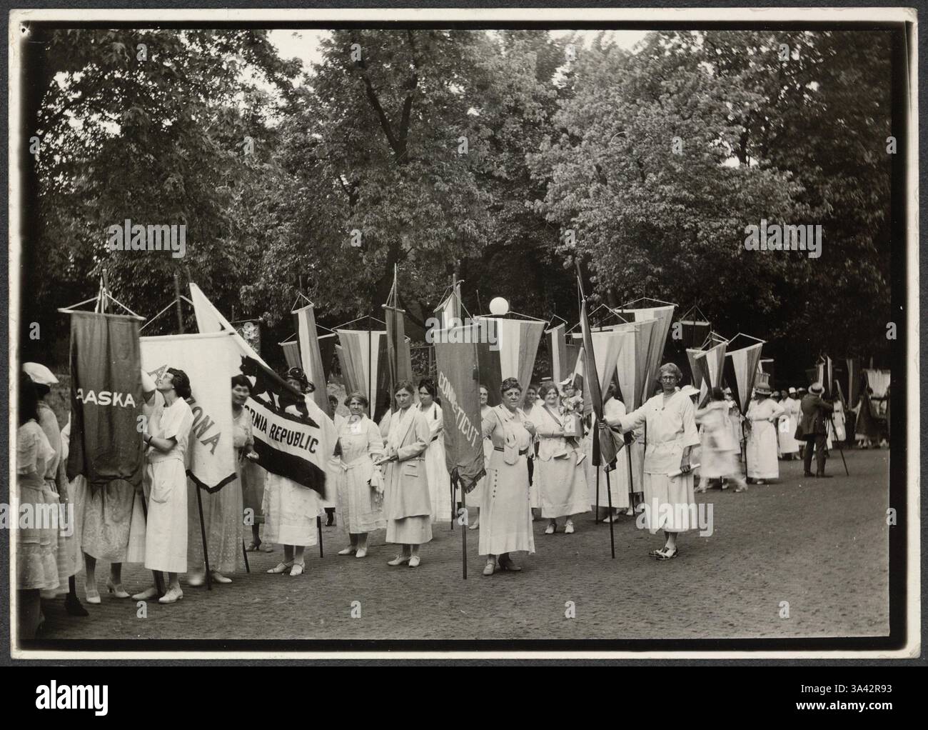 Photographie des membres du Parti national des femmes se rassemblant dans la rue avec des bannières. Parmi les bannières figurent celles qui lisent « Nebraska », « California Republic », Connecticut. Les suffragettes plaident pour la ratification du 19e amendement à la Constitution des États-Unis, qui accorde aux femmes le droit de vote. L'amendement a été ratifié le 18 août 1920, après que le Tennessee est devenu le 36e État à l'approuver, réunissant la majorité requise des trois quarts des états. Les organisations de suffrage comme la National American Woman suffrage Association (NAWSA) et le National Woman’s Party (NWP) ont utilisé des bannières, des protestations, une Banque D'Images