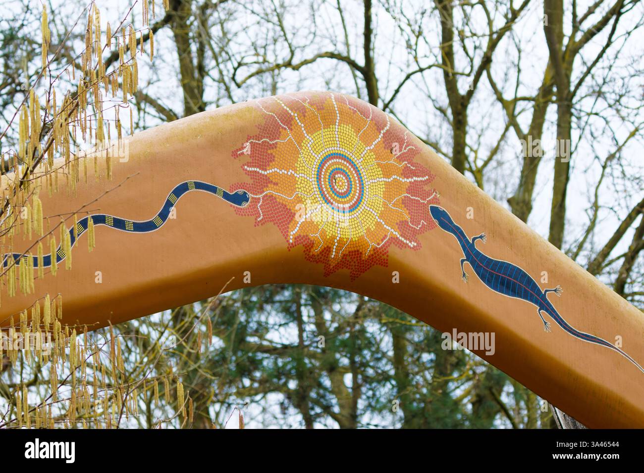 Art aborigène sur sculpture de Boomerang avec motifs serpent et lézard. Œuvres d'art colorées de style aborigène sur une grande sculpture de boomerang avec serpent et Li Banque D'Images