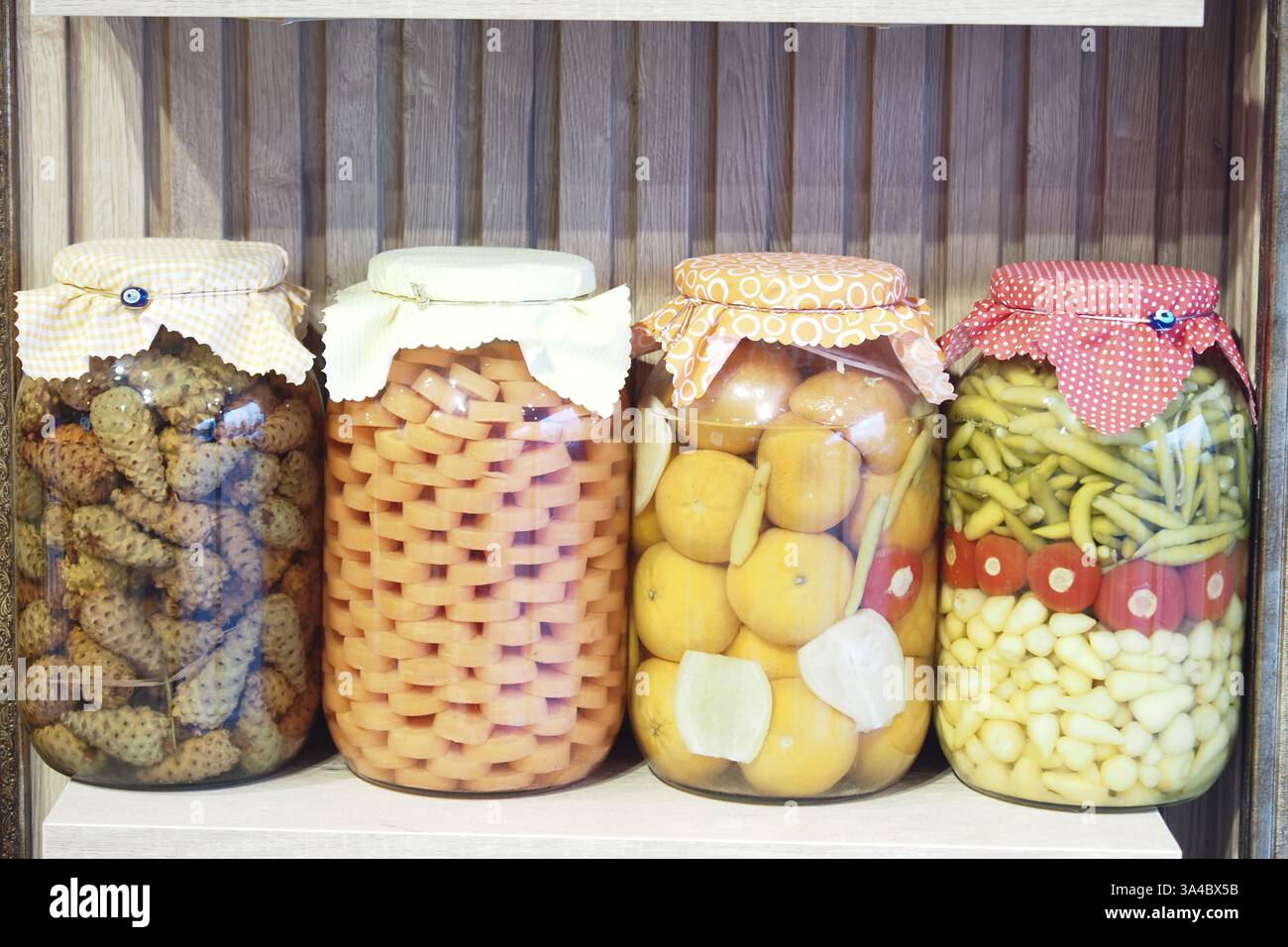 Pots colorés de fruits et légumes conservés tapissés sur une étagère Banque D'Images