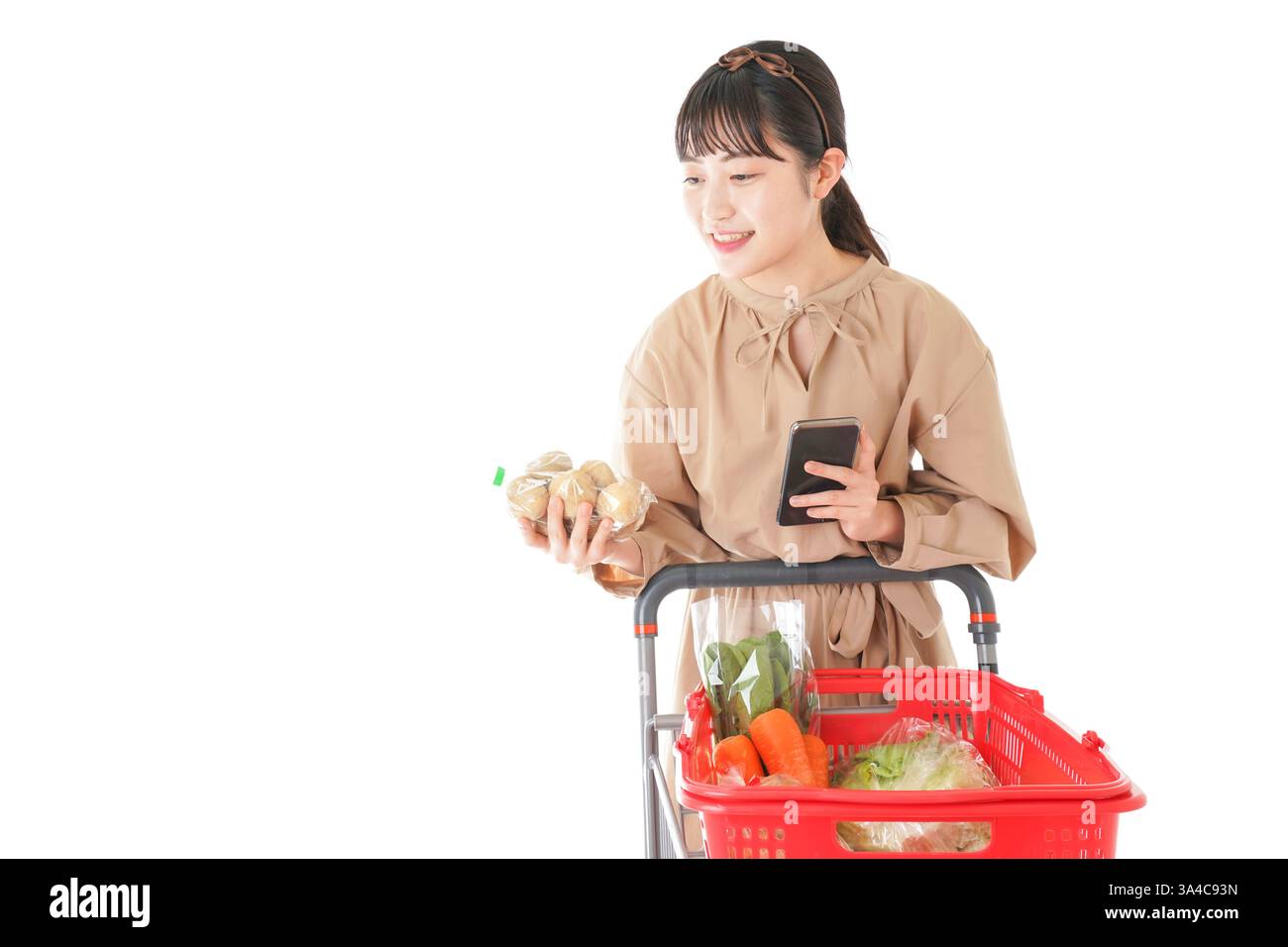 Jeune femme vérifiant l'origine de la nourriture dans le supermarché Banque D'Images