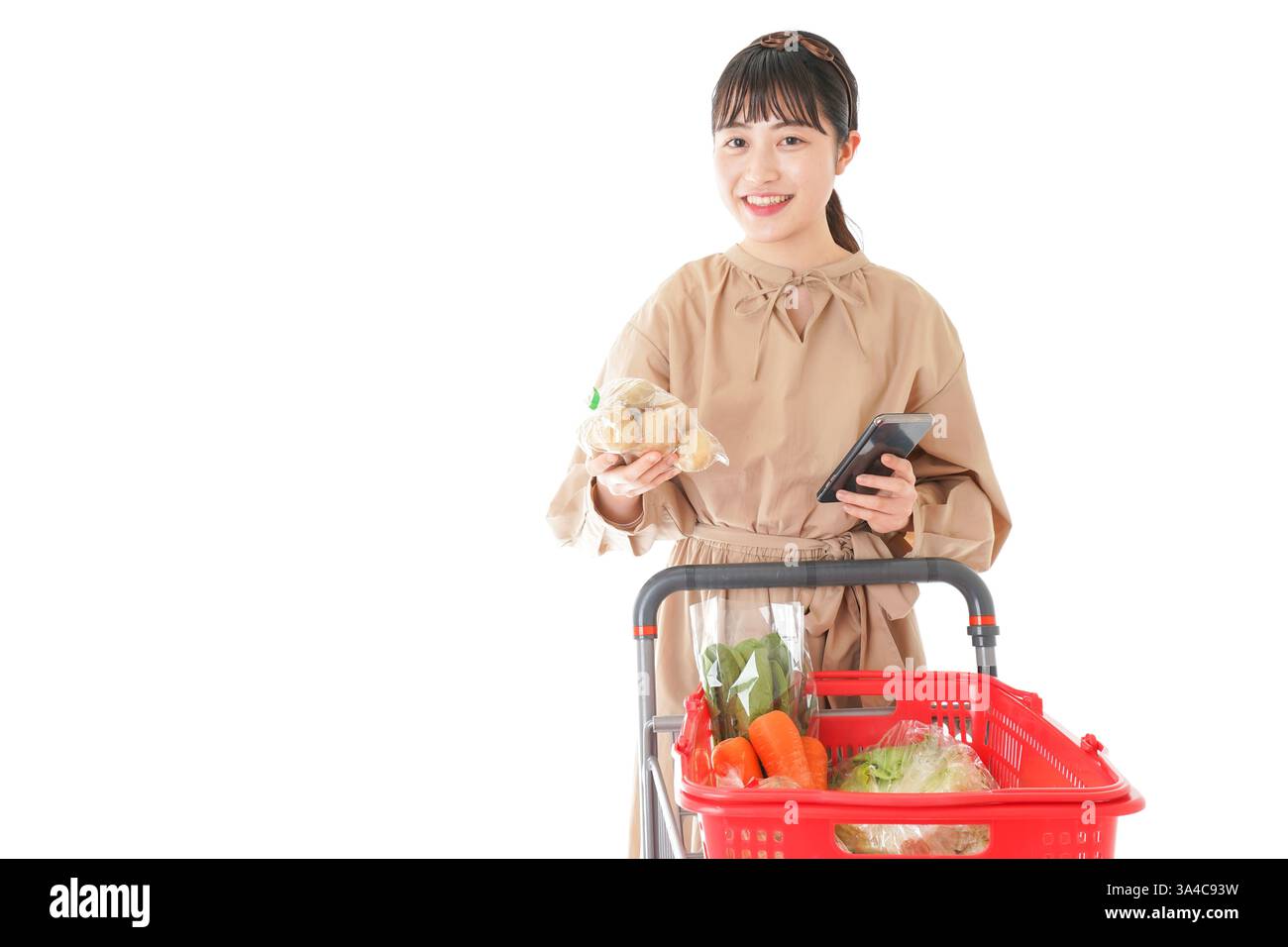 Jeune femme vérifiant l'origine de la nourriture dans le supermarché Banque D'Images