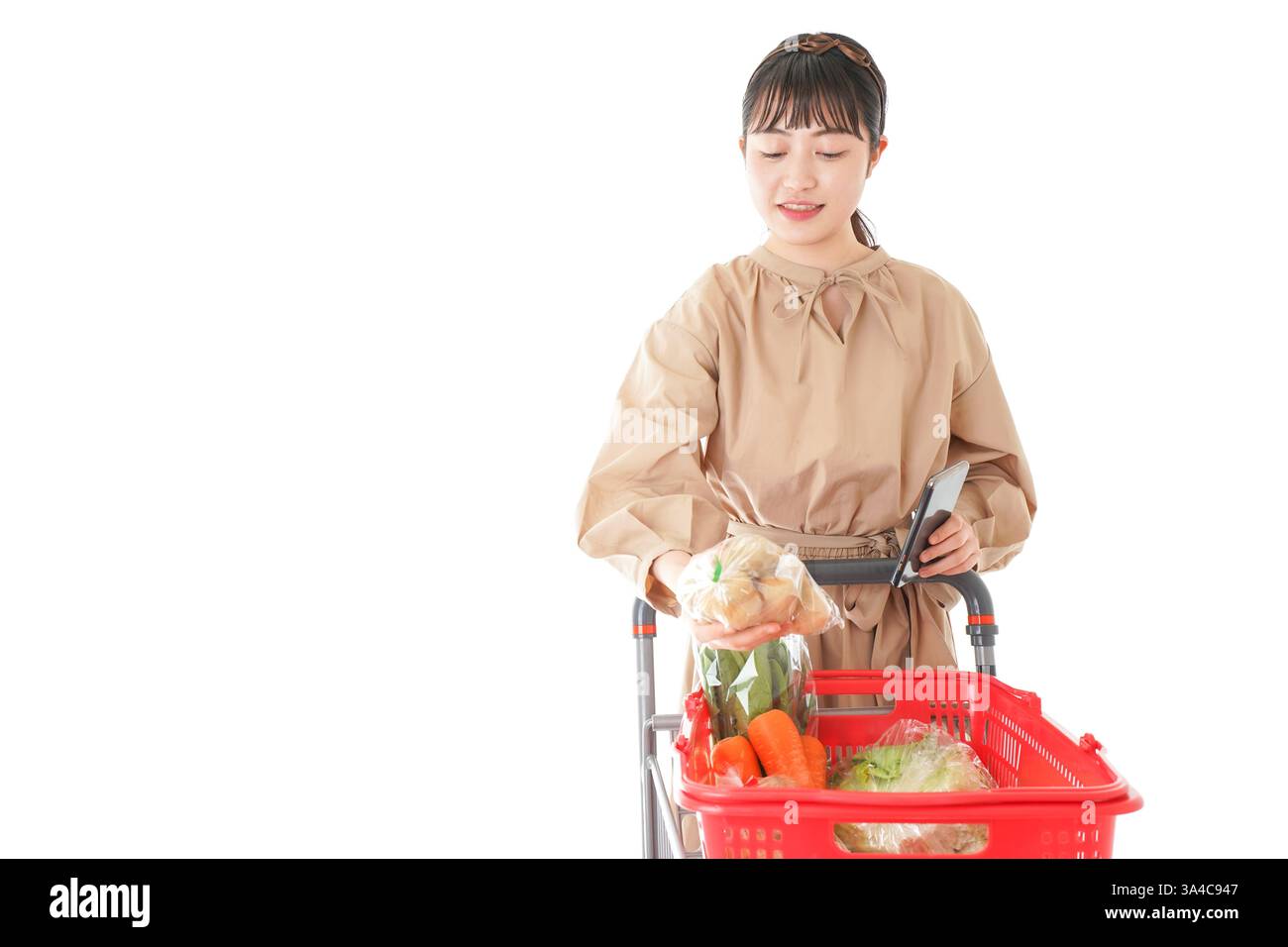 Jeune femme vérifiant l'origine de la nourriture dans le supermarché Banque D'Images