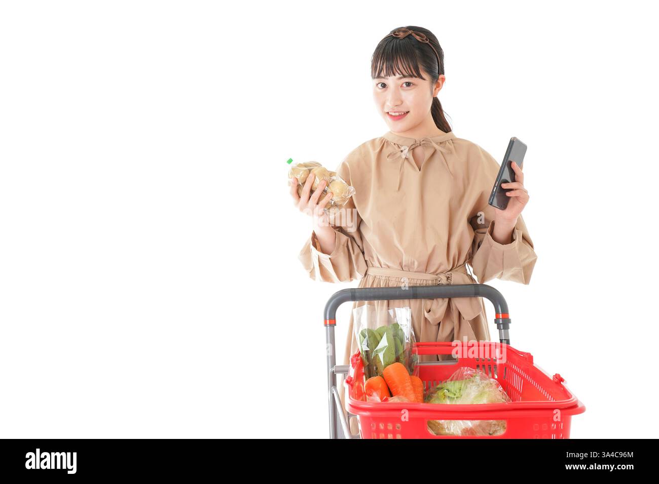 Jeune femme vérifiant l'origine de la nourriture dans le supermarché Banque D'Images