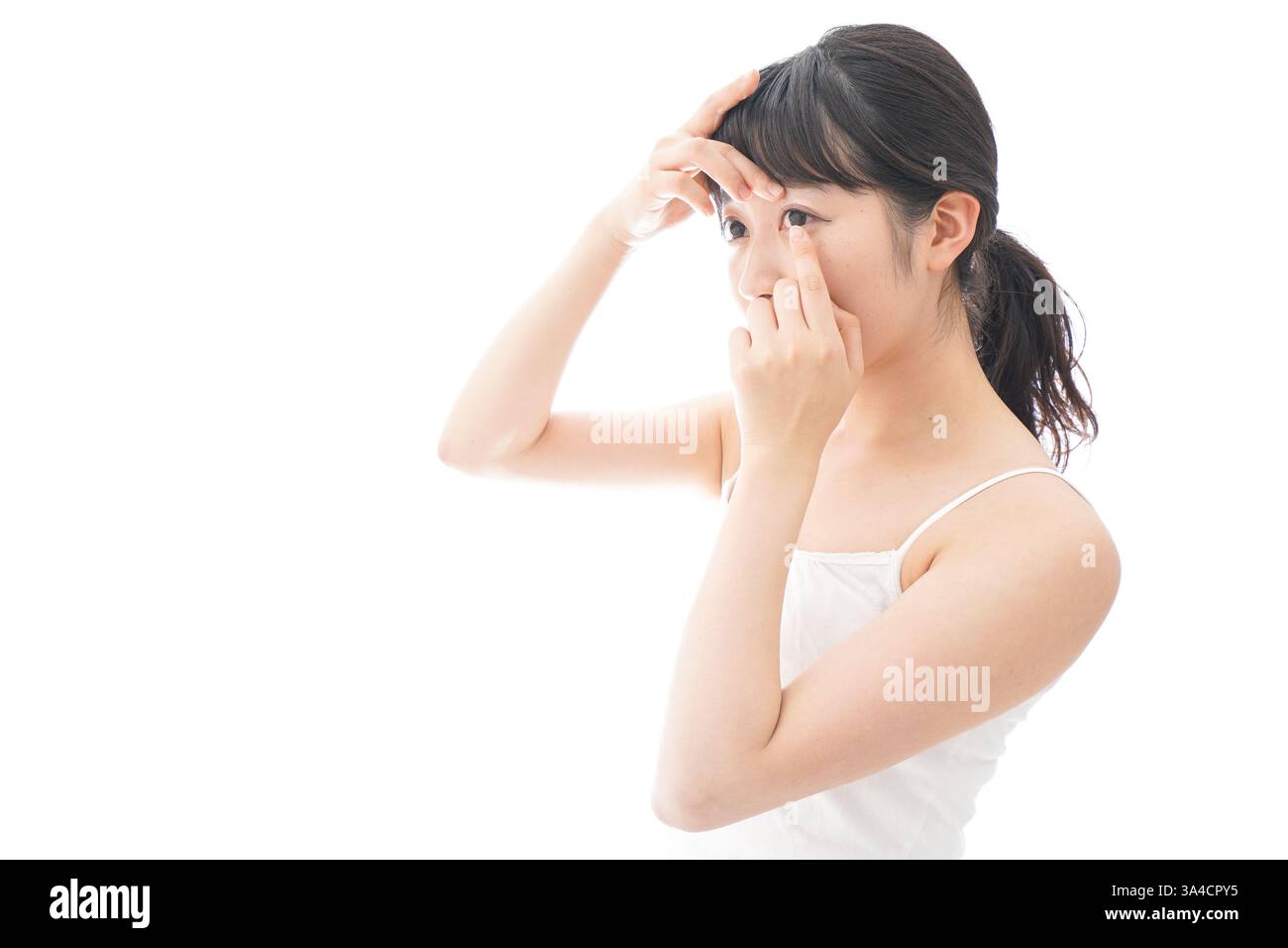 Jeune femme mettant des lentilles de contact Banque D'Images