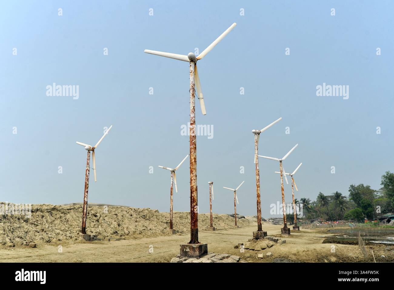 Autrefois symbole d’espoir pour l’énergie verte, les éoliennes rouillées de l’île de Kutubdia sont aujourd’hui abandonnées. Une fois opérationnels et produisant de l’électricité, ils sont tombés en délabrement, suscitant des inquiétudes quant à la mauvaise gestion et à l’avenir des initiatives du Bangladesh en matière d’énergies renouvelables. Île de Kutubdia, Bangladesh. Banque D'Images