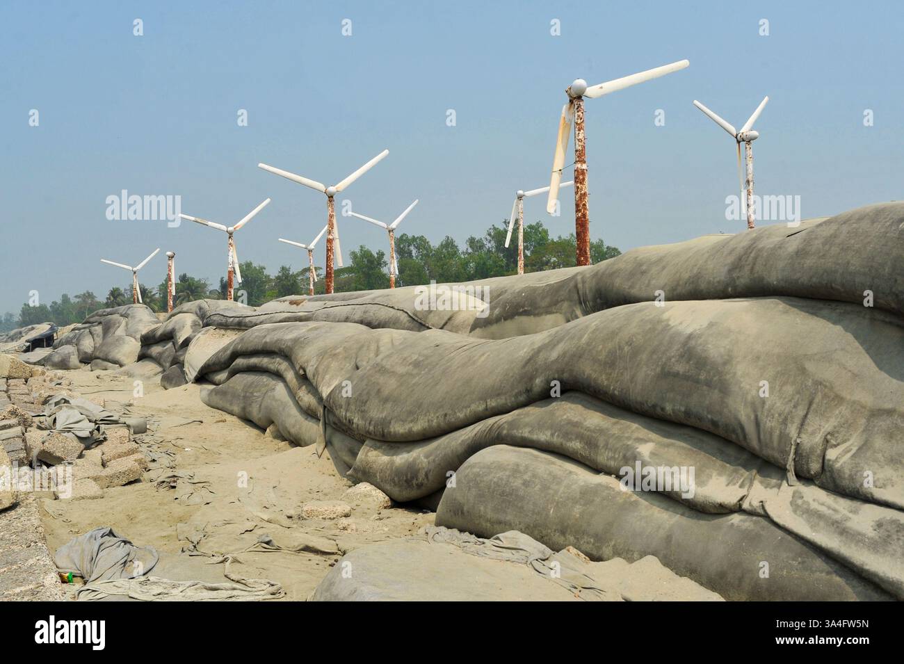 Autrefois symbole d’espoir pour l’énergie verte, les éoliennes rouillées de l’île de Kutubdia sont aujourd’hui abandonnées. Une fois opérationnels et produisant de l’électricité, ils sont tombés en délabrement, suscitant des inquiétudes quant à la mauvaise gestion et à l’avenir des initiatives du Bangladesh en matière d’énergies renouvelables. Île de Kutubdia, Bangladesh. Banque D'Images