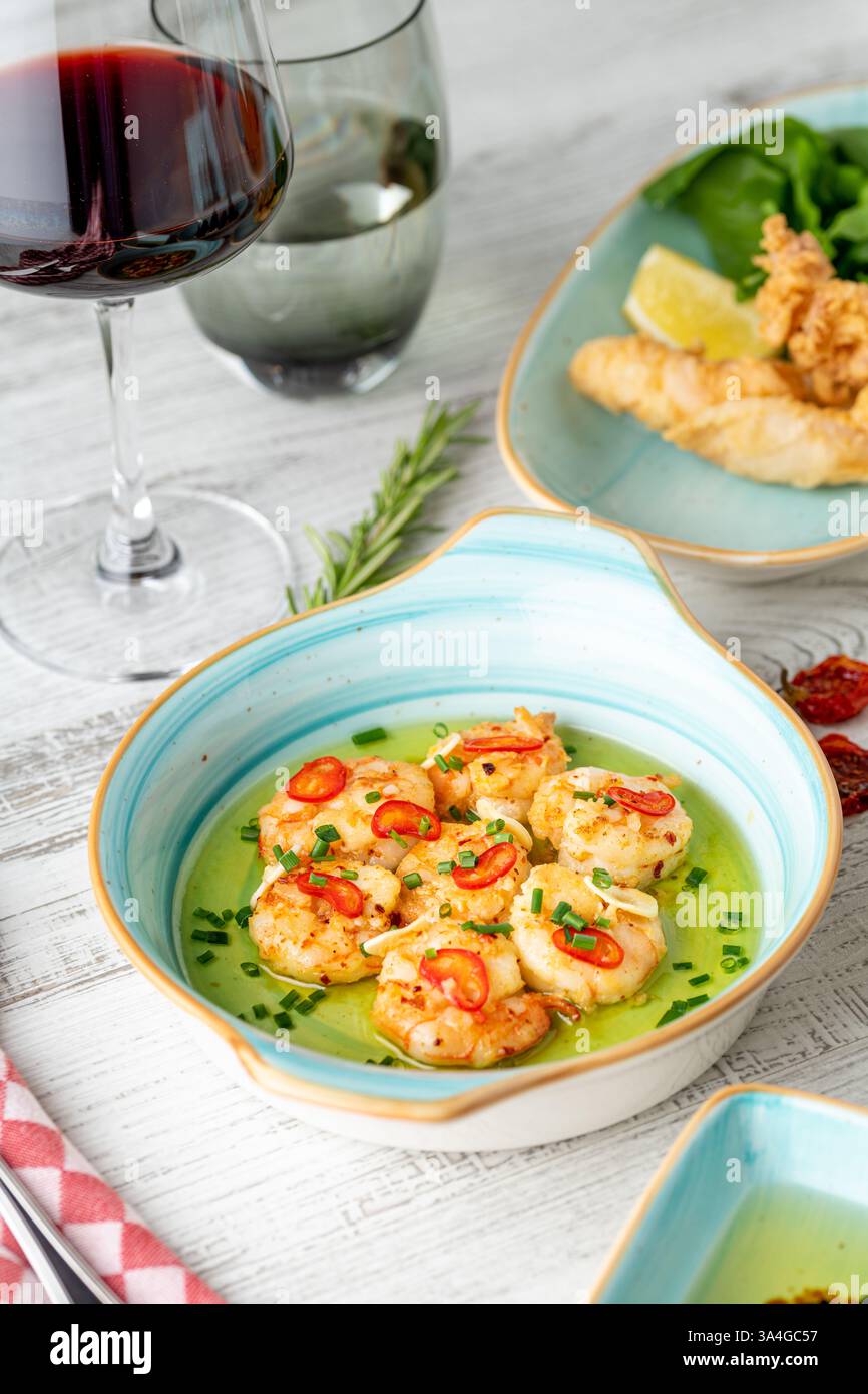 Apéritif avec des crevettes, des oignons et des tomates sur une assiette en porcelaine blanche Banque D'Images