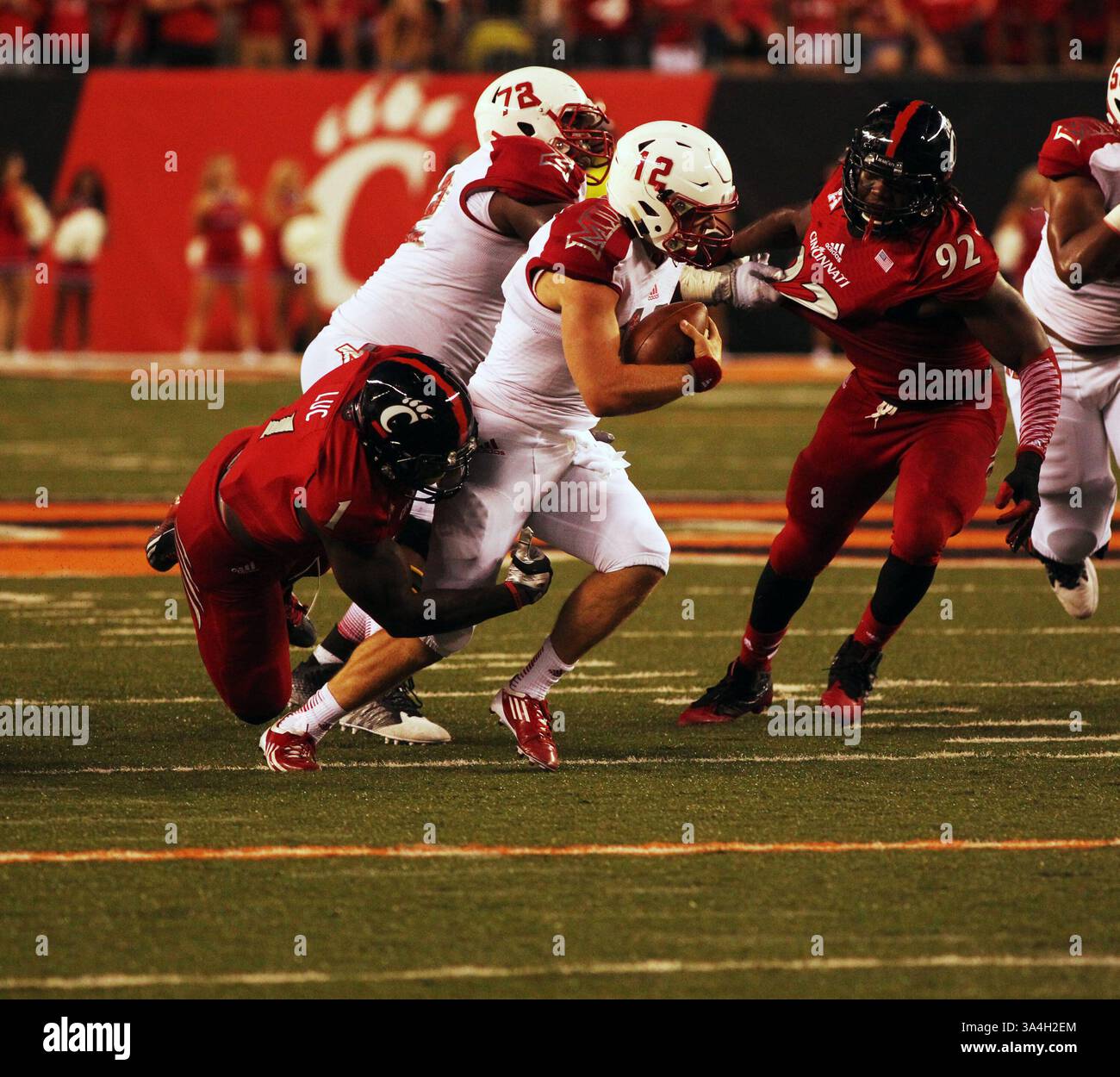 20 septembre 2014 - Cincinnati, Ohio, U. S - Miami (OH) le quarterback des Redhawks Andrew Hendrix (12) est abattu dans le deuxième quart de jeu par Jeff Luc (1), linebacker des Cincinnati Bearcats. Le samedi 20 septembre 2014 pendant le match au Paul Brown Stadium. (Crédit image : © Ernest Coleman/ZUMA Wire) Banque D'Images