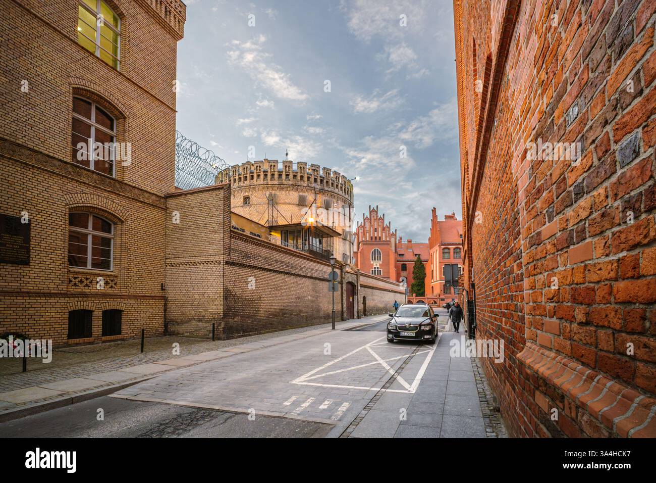 Saisissant le contraste saisissant du centre de détention de Okrąglak à Toruń, mêlant architecture historique et vie urbaine contemporaine. Banque D'Images