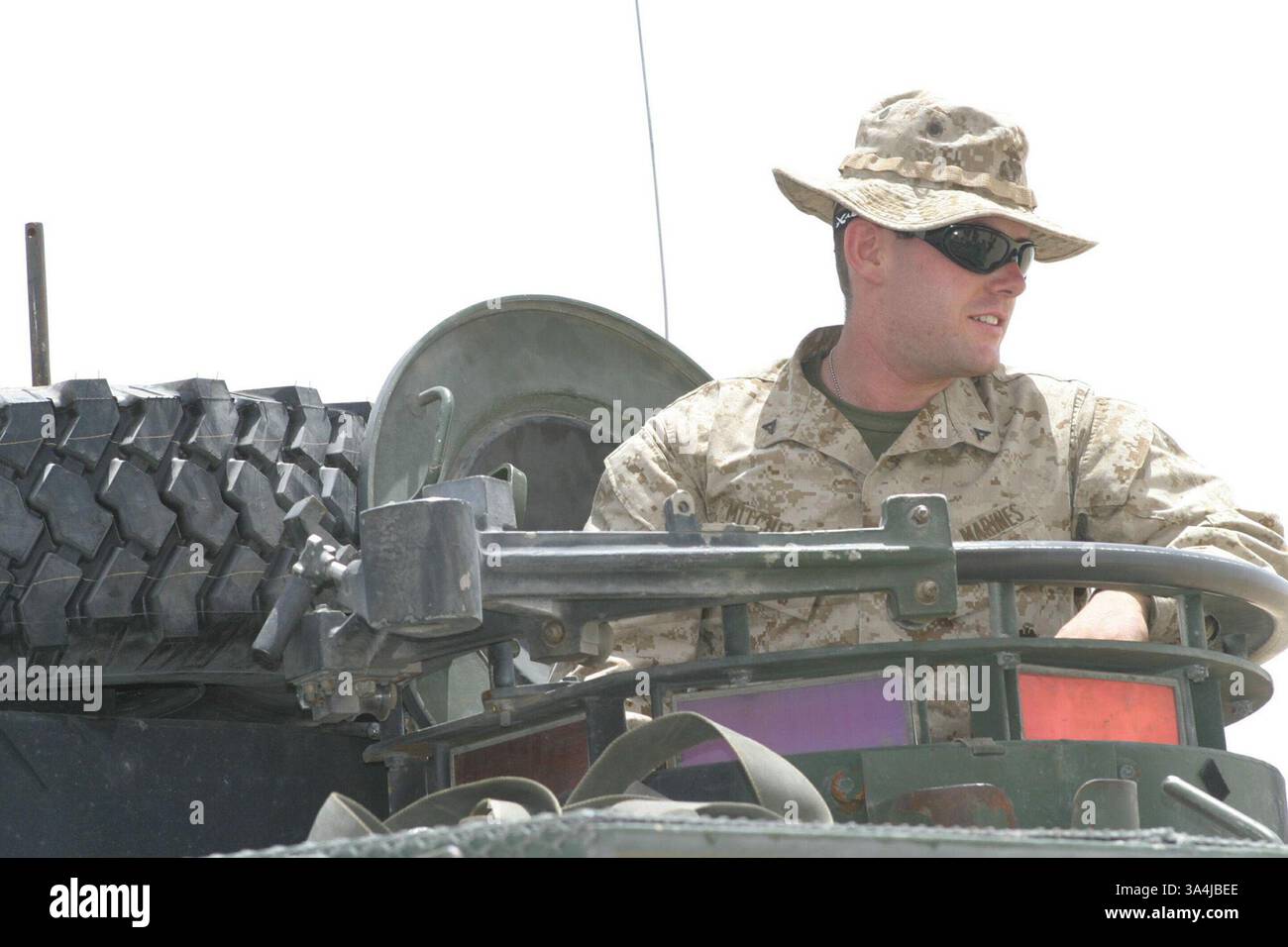 12 juillet 2004 ; Central, Koweït ; lance Cpl SCOTT MITCHELL, 20 ans, un Sacramento, Calif, natif de la 24e Marine Expeditionary Unit se tient à l'intérieur de son véhicule blindé léger après avoir attaché une pièce de rechange au sommet de celui-ci. Mitchell est un membre d'équipage du LAV avec le peloon de reconnaissance blindé léger, attaché à la compagnie d'armes du 1er Bataillon 2nd Marines. Le MEU est arrivé au Koweït pour commencer l'acclimatation et la formation complémentaire avant de partir pour leur destination en Iraq. Banque D'Images