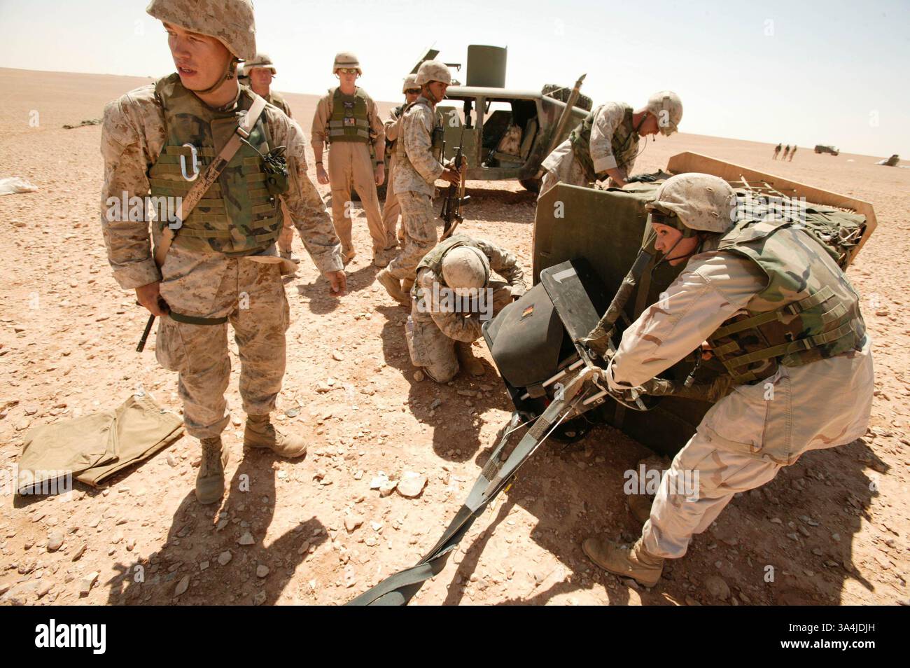 09 août 2004 ; Camp Korean Village, Irak ; les gréeurs de parachutistes marins du 1er peloton de livraison aérienne, le Cpl CHRISTOPHER J. HYMEL, à gauche, et le Cpl AMANDA J. RUHSAM, commencent à détacher un système de parachute cargo de précision Sherpa du sommet d'un paquet de rations près du Camp Korean Village, Irak, le 9 août 2004. Deux systèmes Sherpa ont fait leurs premiers vols et atterrissages de précision dans une zone de combat le 9 août. Le Sherpa est un système produit commercialement guidé par le système de positionnement global qui peut se diriger de près de cinq miles de haut à moins de 200 mètres d'un point de chute ciblé. Le peloton, qui est Banque D'Images
