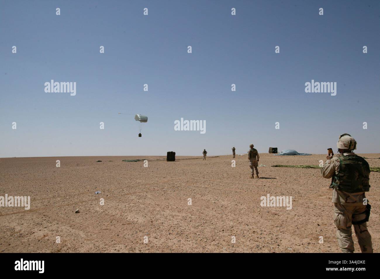 09 août 2004 ; Camp Korean Village, Irak ; le deuxième des deux systèmes de parachute cargo de précision Sherpa approche du sol près du Camp Korean Village marquant sa première utilisation en Irak le 9 août 2004. Le Sherpa est un système produit commercialement guidé par le système de positionnement global qui peut se diriger de près de cinq miles de haut à moins de 200 mètres d'un point de chute ciblé. Le 1er peloton de livraison aérienne, qui fait partie du bataillon de soutien des services de combat 7, a reçu les Sherpas du corps multinational - Irak, à Bagdad. Le peloton débarque des charges de fournitures pour les troupes dans des endroits éloignés. CSSB- Banque D'Images