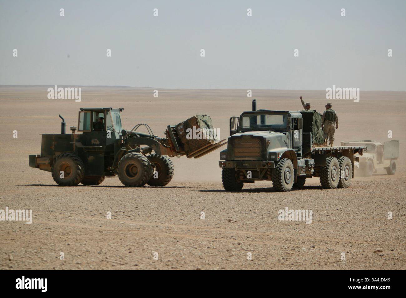 09 août 2004 ; Camp Korean Village, Irak ; Marines de la Compagnie Echo, 2e bataillon, 11e régiment de Marines, rassemblent des paquets de rations à l'extérieur du Camp Korean Village, Irak, après que la nourriture a été parachutée le 9 août 2004. En utilisant des parachutes militaires standard, les avions cargo doivent voler à des altitudes plus basses pour assurer des largages précis, mais sont plus sensibles aux tirs ennemis. Avec le Sherpa, un système de parachute produit commercialement et guidé par le Global Positioning System qui peut se diriger de près de cinq miles de haut à moins de 200 mètres d'un point de largage ciblé, les avions militaires peuvent larguer des approvisionnements à partir de Safer Banque D'Images