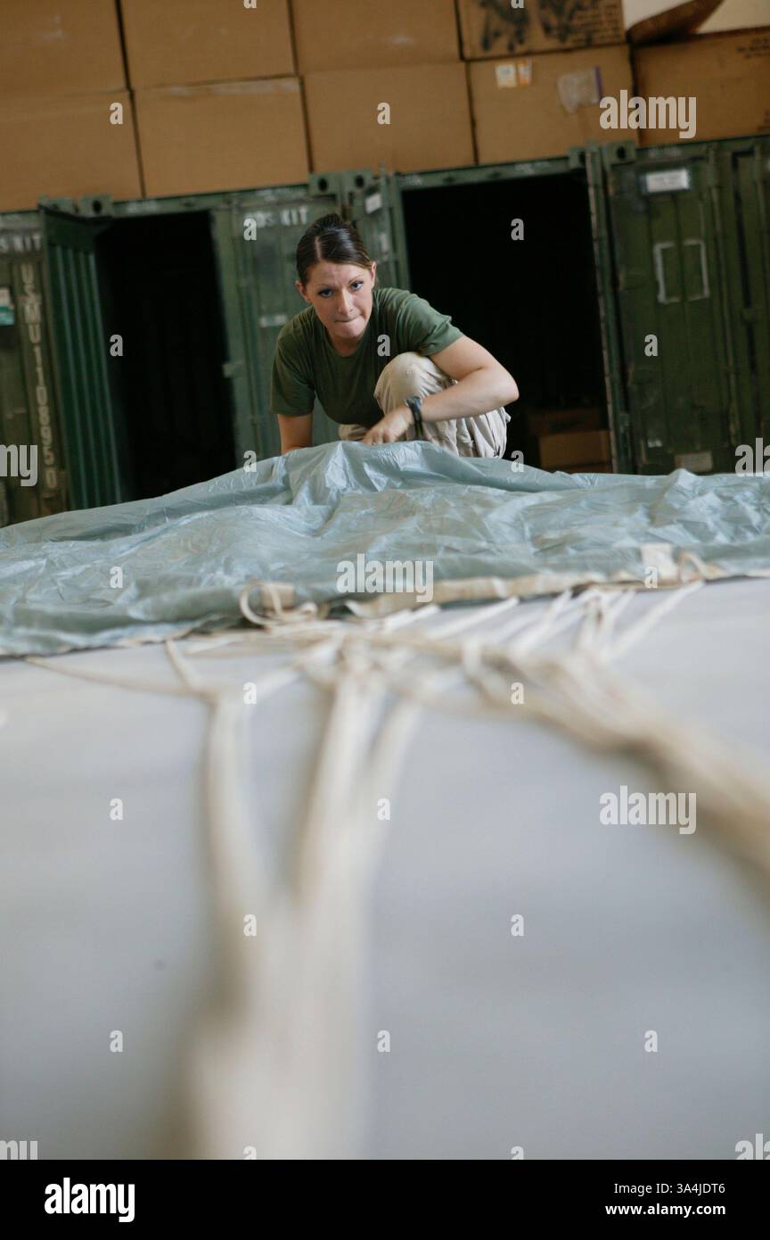 10 août 2004 ; Camp Al Asad, Irak ; le Cpl. AMANDA J. RUHSAM, gréviste de parachutistes du 1er peloton de livraison aérienne, déploie la canopée d'un système de parachute cargo de précision Sherpa au Camp Al Asad, Irak, le 10 août 2004, afin de le reconditionner pour sa prochaine mission. Deux systèmes Sherpa ont fait leurs débuts dans la zone de combat et des atterrissages de précision près du Camp Korean Village le 9 août. Le Sherpa est un système produit commercialement guidé par le système de positionnement global qui peut se diriger de près de cinq miles de haut à moins de 200 mètres d'un point de chute ciblé. Le peloton, qui fait partie de combat servi Banque D'Images