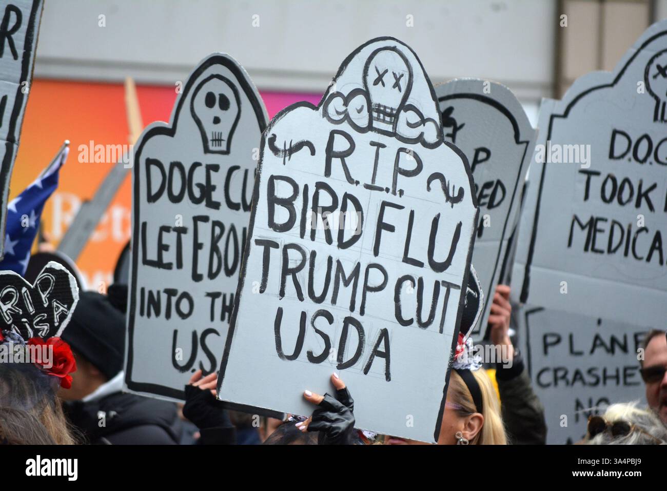 Manifestants avec de fausses pierres tombales lors d'un rassemblement Stop the Cuts contre DOGE dans Lower Manhattan. Banque D'Images