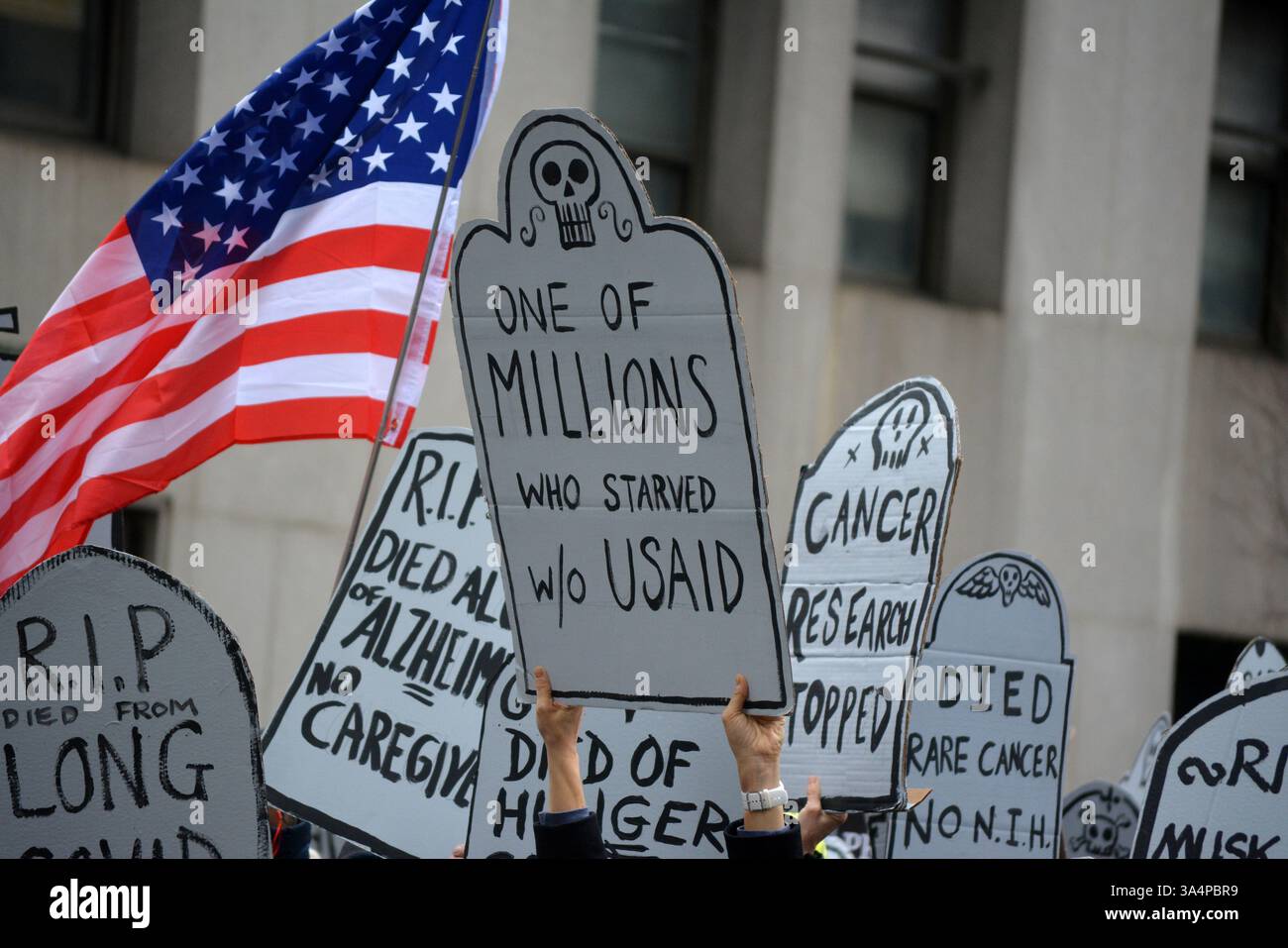 Manifestants avec de fausses pierres tombales lors d'un rassemblement Stop the Cuts contre DOGE dans Lower Manhattan. Banque D'Images