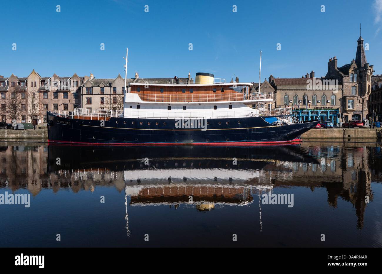 Leith, Édimbourg, Écosse, Royaume-Uni, 19 mars 2025. Météo britannique : le deuxième jour de soleil glorieux et un ciel bleu clair mais encore froid. Sur la photo : Hôtel flottant Ocean Mist sur le rivage se reflète dans l'eau de la rivière Leith. Crédit : Sally Anderson/Alamy Live News Banque D'Images