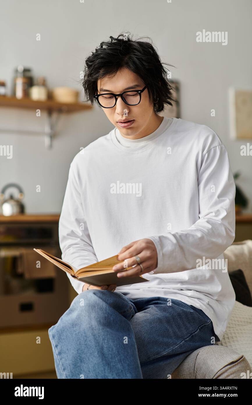 Un étudiant engagé explore l'e-learning sur son ordinateur portable depuis un espace de vie confortable et accueillant. Banque D'Images