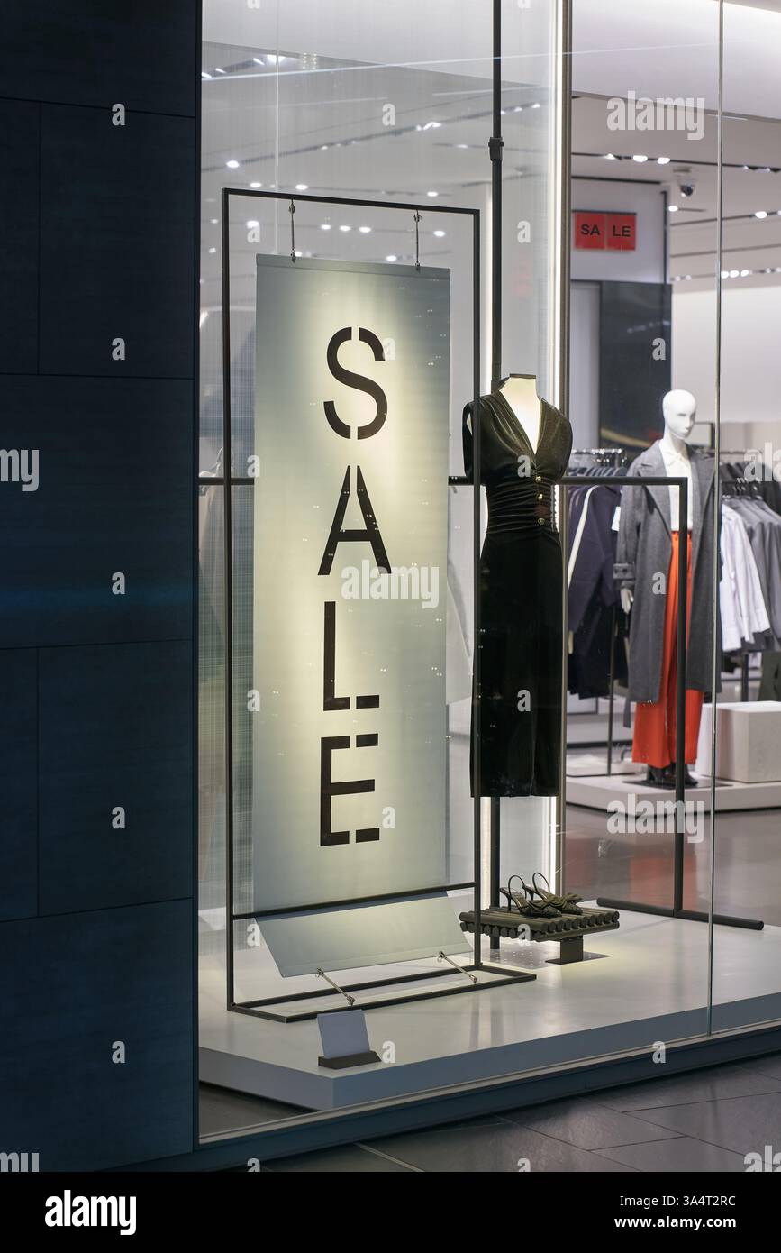Vitrine illuminée d'un magasin de vêtements avec le lettrage Sale dans le centre-ville de Dresde, Allemagne Banque D'Images