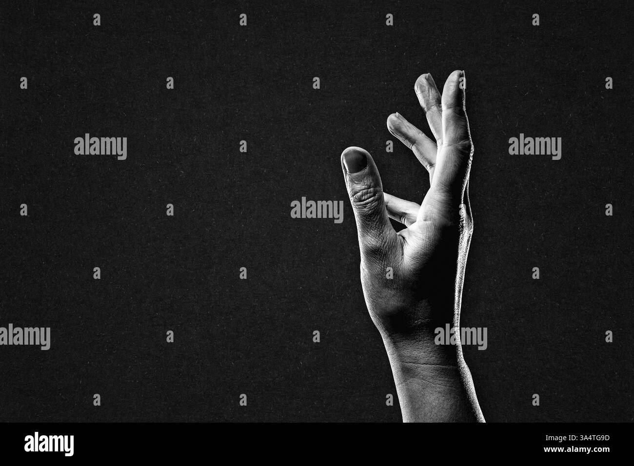 Main atteignant signe en noir et blanc sur fond de papier texturé, espace de copie Banque D'Images