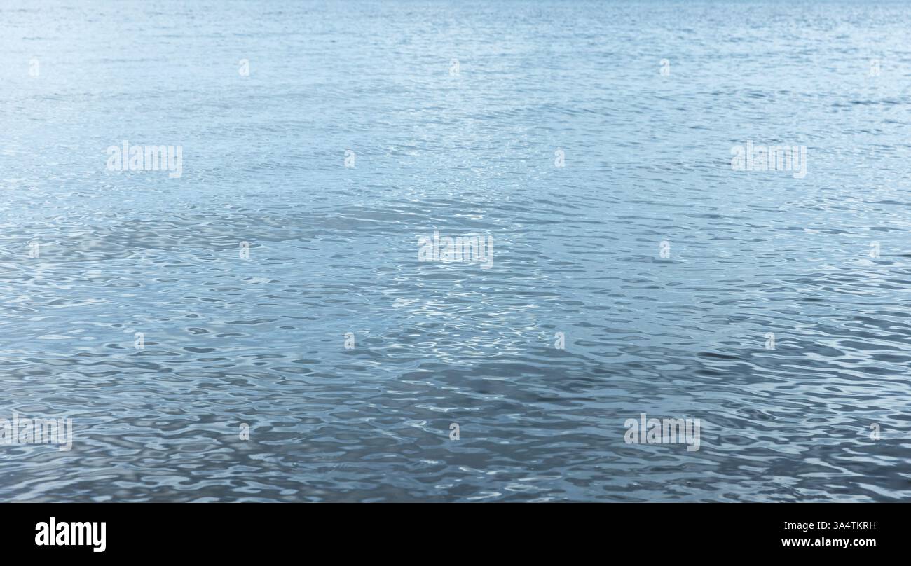 Eau de mer bleu serein avec vagues ondulantes sous la lumière du jour, créant une ambiance apaisante et paisible. La tranquillité de la nature est capturée dans le flui Banque D'Images
