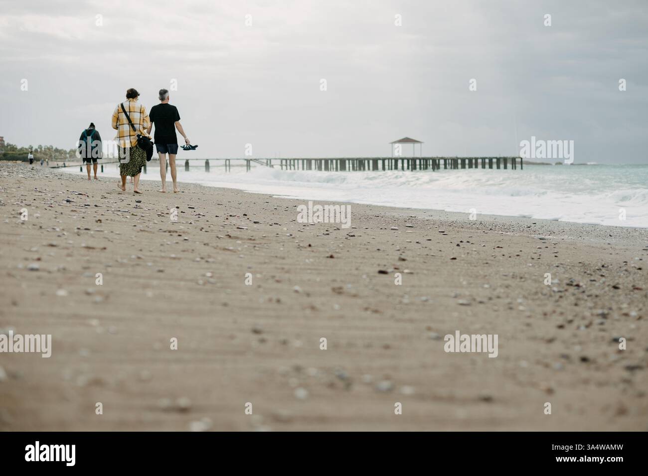 Gens marchant sur une plage rocheuse en Turquie – vacances d'automne Banque D'Images