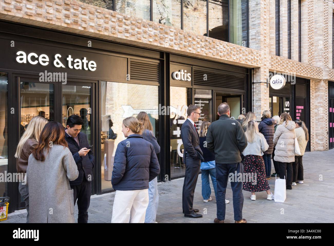 Clients enthousiastes faisant la queue devant le restaurant d'aliments naturels atis Borough Yards, Dirty Lane, Borough, London, SE1, Angleterre, Royaume-Uni Banque D'Images