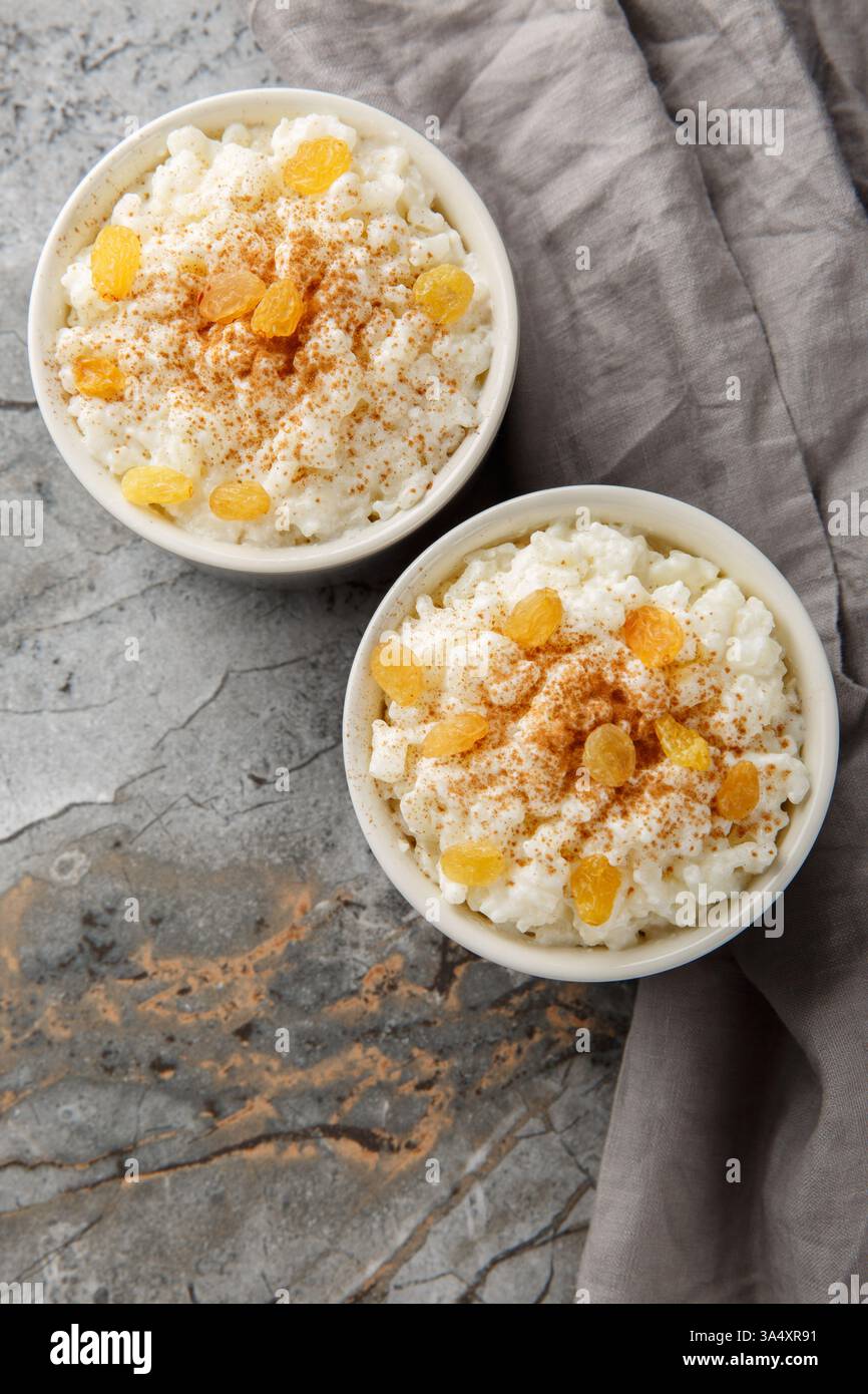 Délicieux pudding de riz à la cannelle, à la vanille et aux raisins secs en gros plan sur le bol sur la table. Vue de dessus verticale Banque D'Images