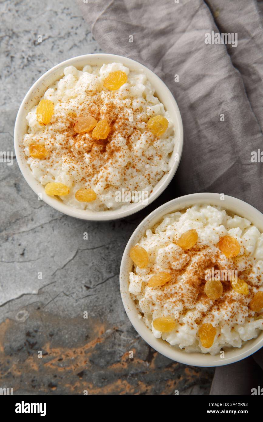 Old-fashioned Rice Pudding est si crémeux avec la texture parfaite et la douceur en gros plan sur le bol sur la table. Vue de dessus verticale Banque D'Images