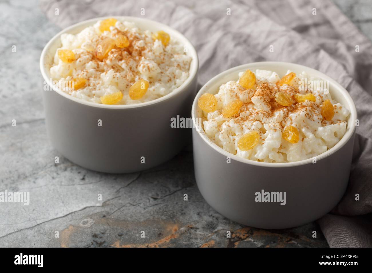 Bol de délicieux pudding de riz avec cannelle, vanille et raisins secs en gros plan sur la table. Horizontal Banque D'Images