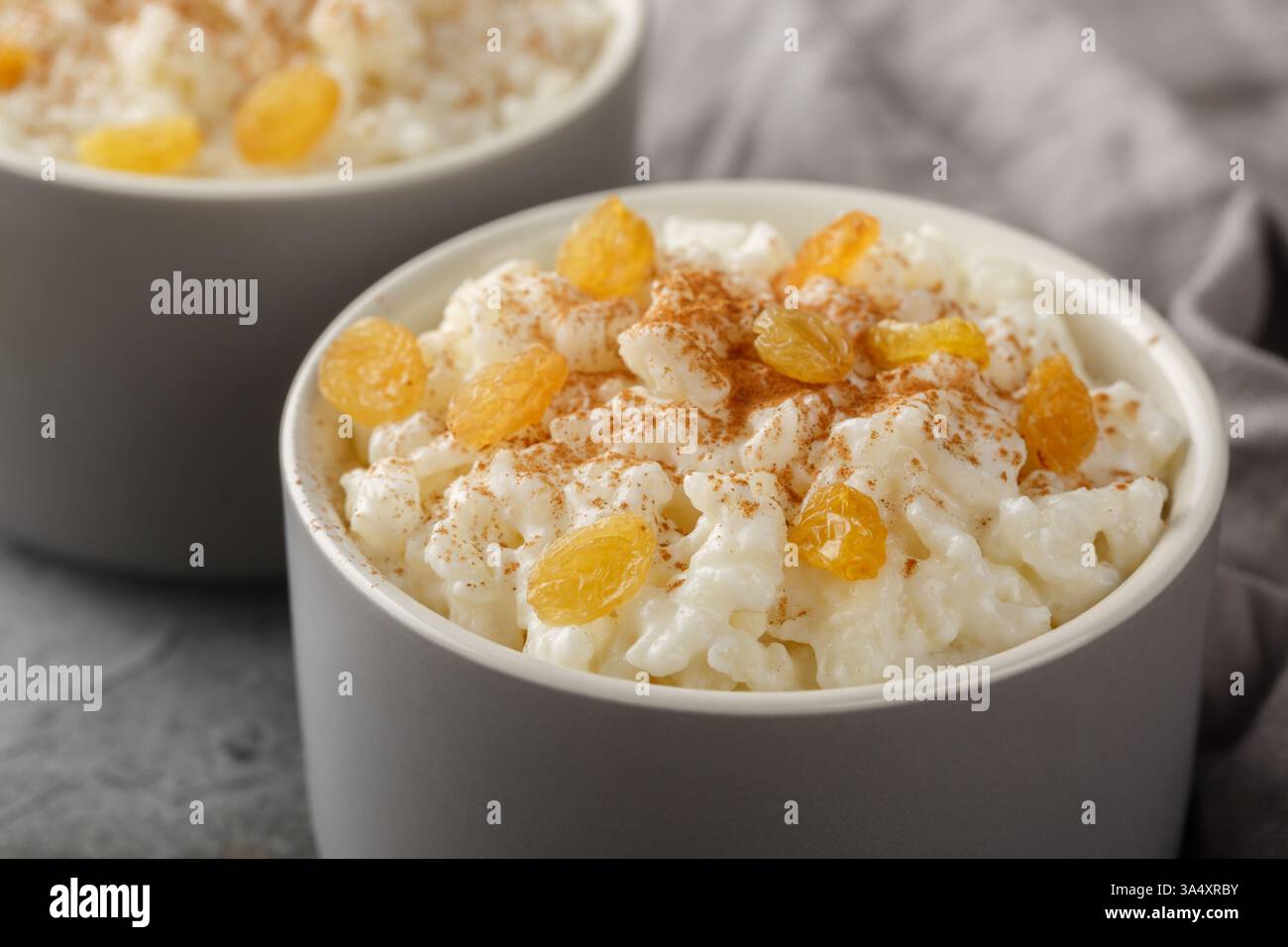 Pudding de riz sucré avec cannelle et raisins secs sur le dessus gros plan dans un ramequin sur la table. Horizontal Banque D'Images
